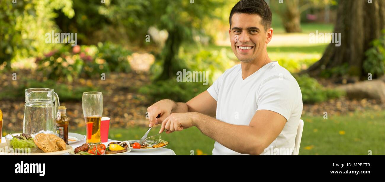 Panorama der glücklichen Mann gesund essen leckere Grillgerichte Stockfoto
