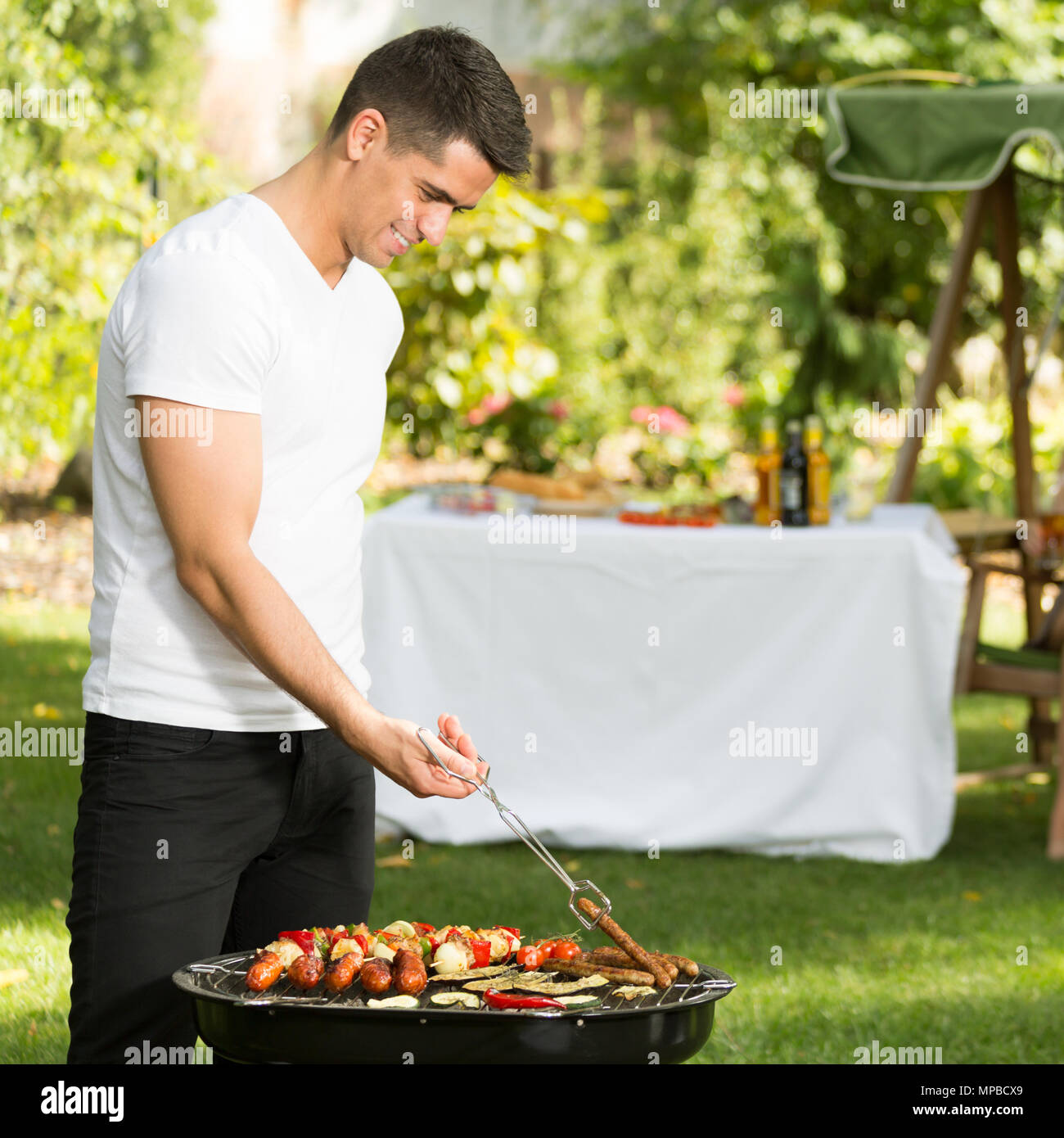 Jungen gutaussehenden Mann und Grill im Sommer am Nachmittag Stockfoto