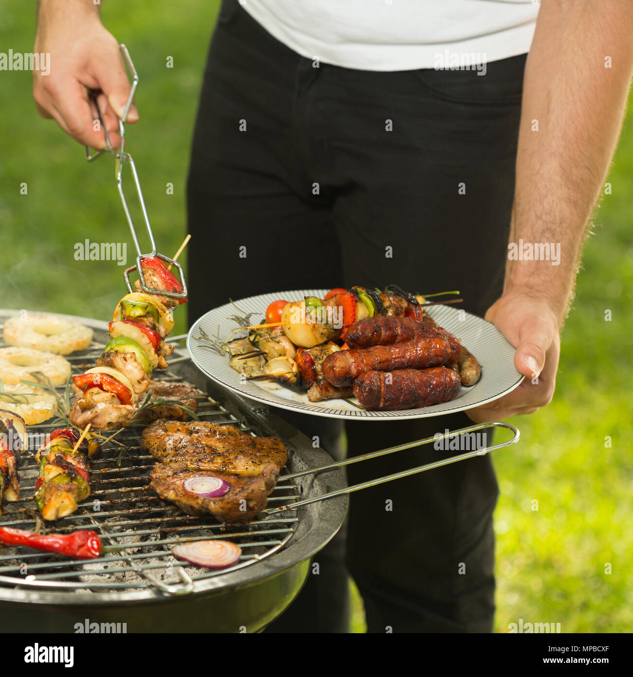 Grill Chef sich das Essen vom Grill Stockfoto
