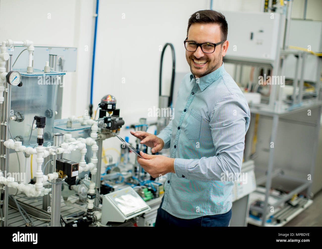 Hübscher junger Mann, der in der elektronischen Werkstatt Stockfoto