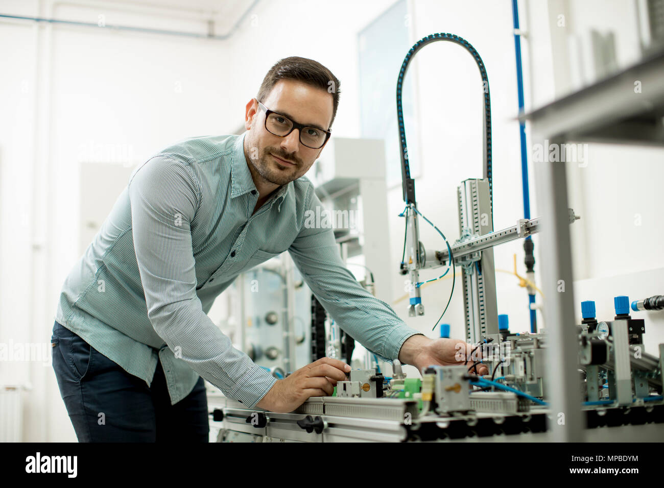 Hübscher junger Mann, der in der elektronischen Werkstatt Stockfoto