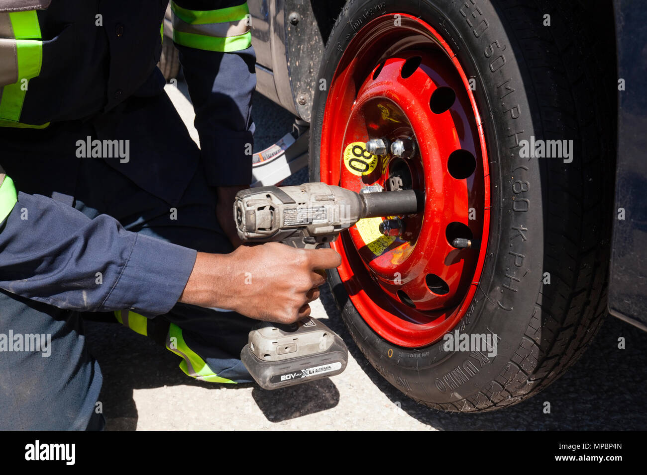 Ein Servicetechniker oder Person ein Reserve Reifen oder Reifen mit einem Schlagschrauber. Stockfoto