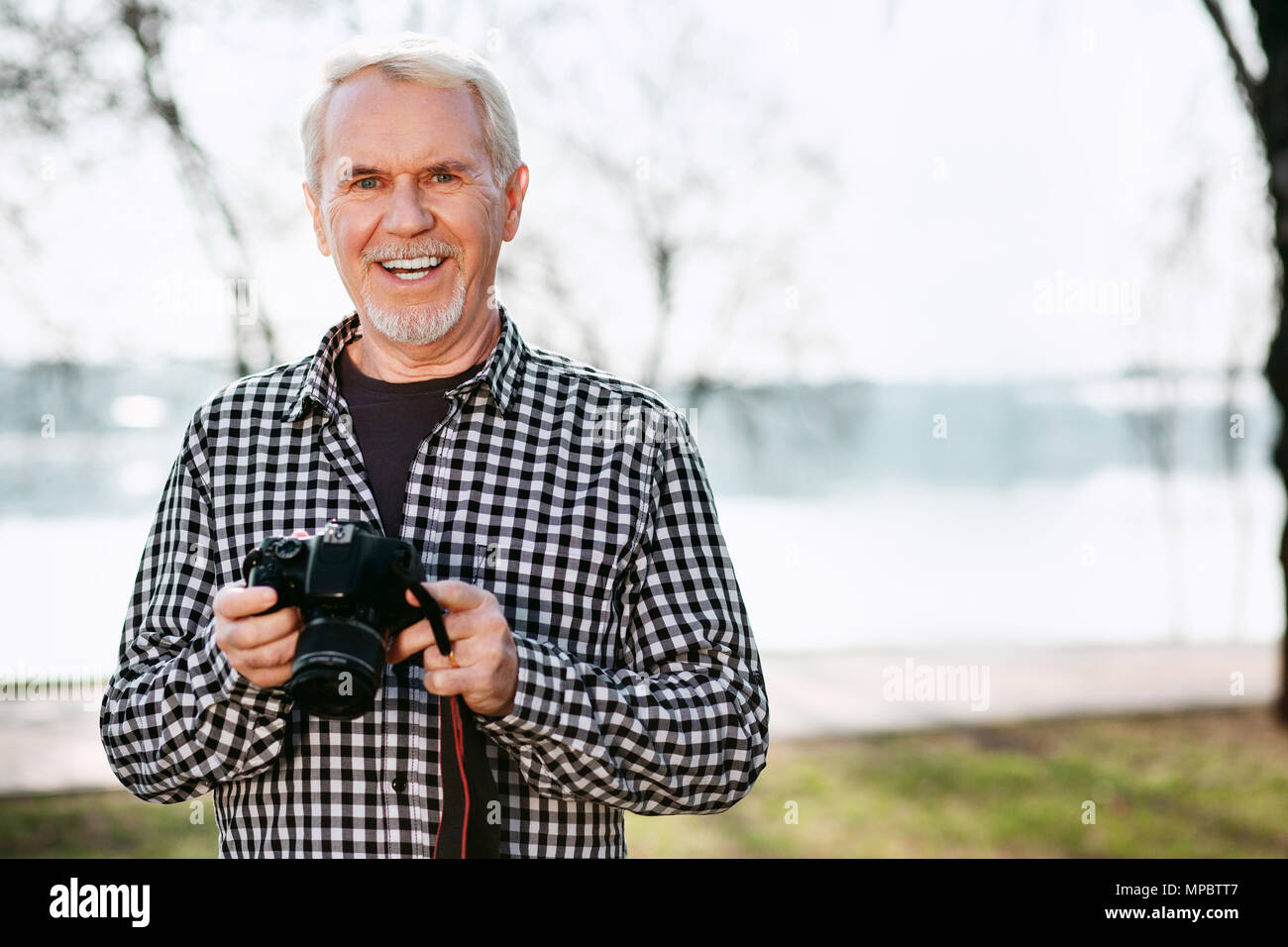 Freudige älterer Mann mit Kamera Stockfoto