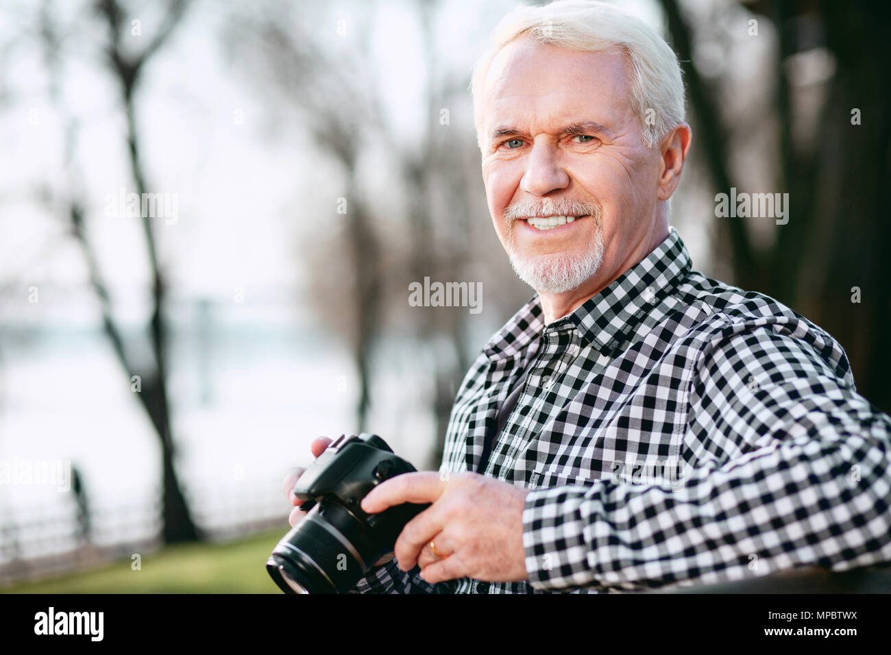 Optimistisch reifer Mann schwierig mit der Fotografie Stockfoto
