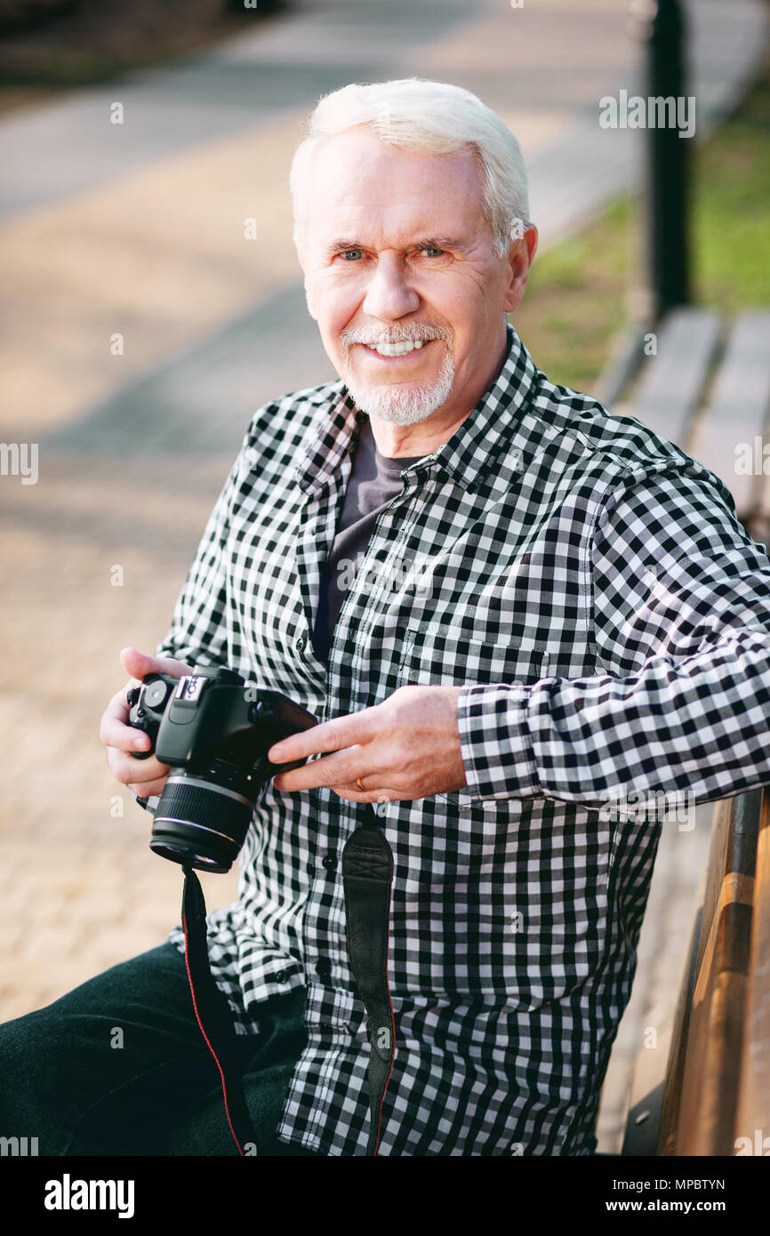 Optimistisch reifer Mann, der versucht, Fotografie Stockfoto