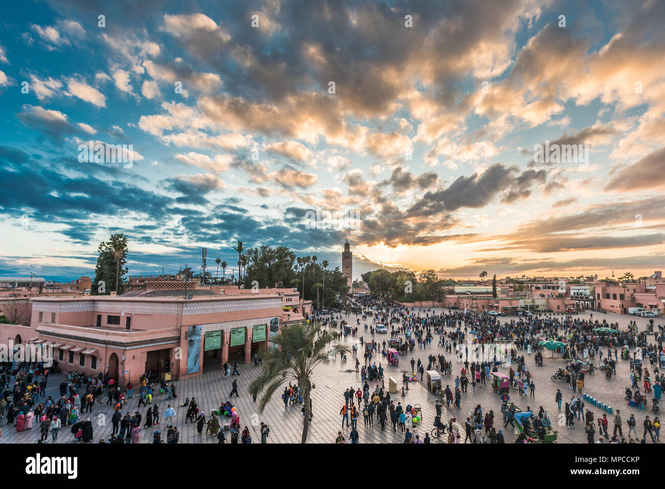 Luftaufnahme von Menschen zu Fuß auf Platz Djemaa El Fnaa Hauptplatz der Stadt. Masse an warmen Sonnenuntergang Farbtöne am Marktplatz in der Medina von Marrakesch. Stockfoto