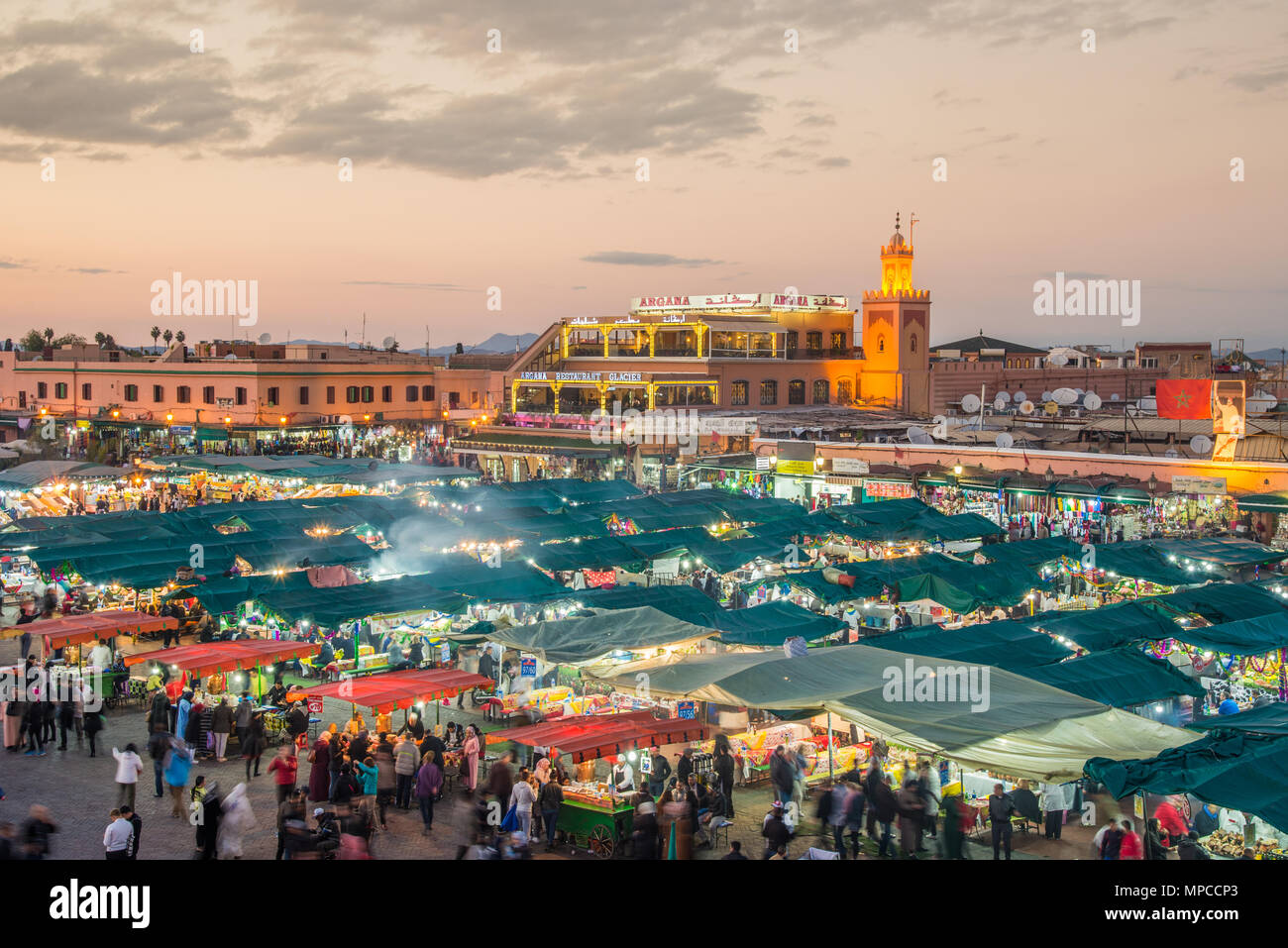 Luftaufnahme von Menschen zu Fuß auf Platz Djemaa El Fnaa Hauptplatz der Stadt. Masse an warmen Sonnenuntergang Farbtöne am Marktplatz in der Medina von Marrakesch. Stockfoto
