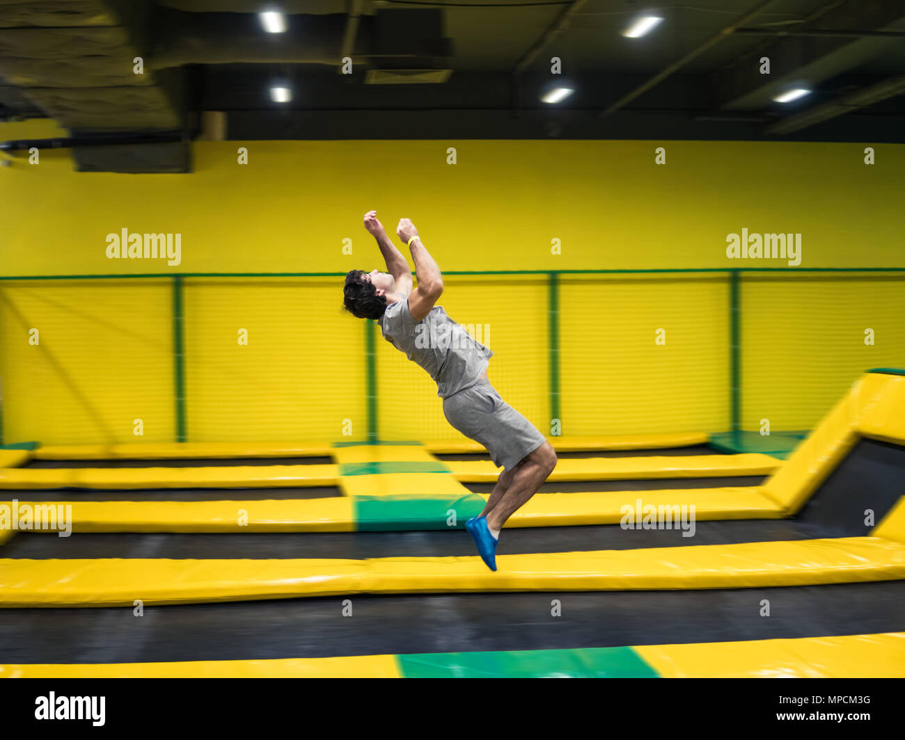 Trampoline Jumper führt akrobatische Übungen auf dem Trampolin Stockfoto