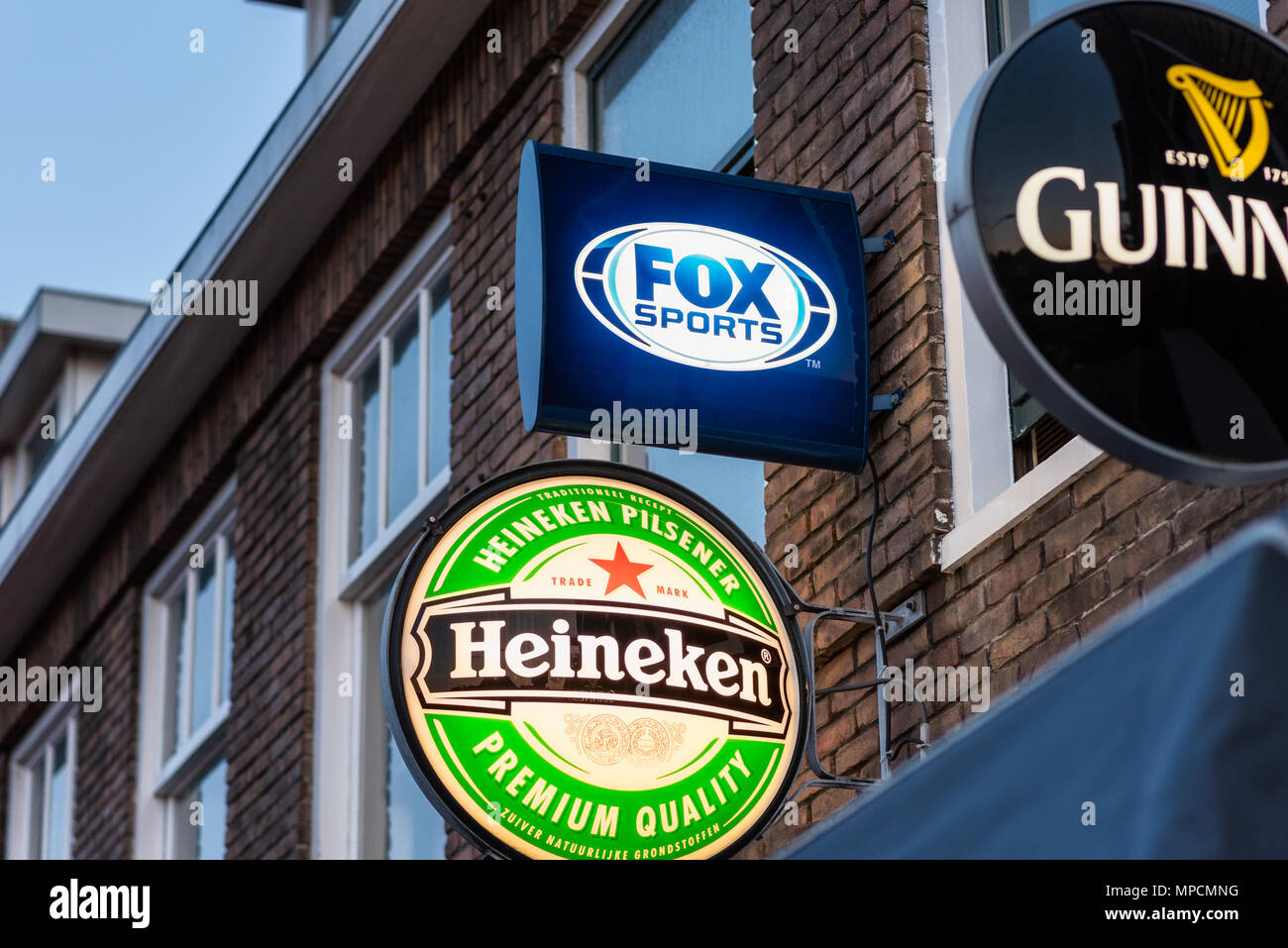 Fox Sports, Heineken und Guinness Logos vor einer Bar in Alkmaar, Niederlande. Fuchs Sport Live-übertragungen professionellen Fußball in den Niederlanden. Stockfoto