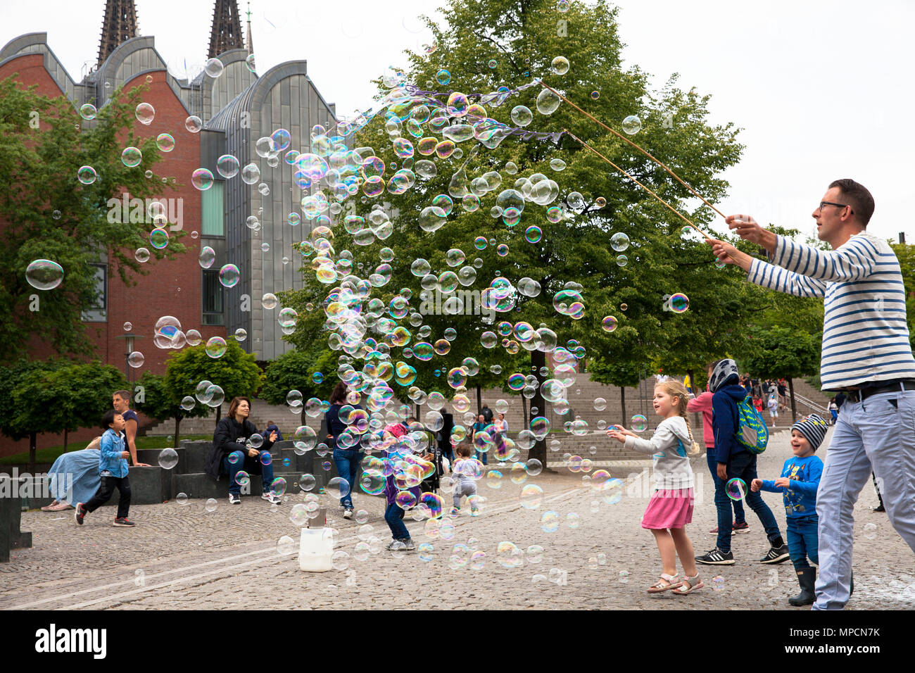 Europa, Deutschland, Köln, Mann macht Seifenblasen am Rhein Garten im alten Teil der Stadt. Europa, Deutschland, Koeln, Mann macht Seifenblasen Stockfoto