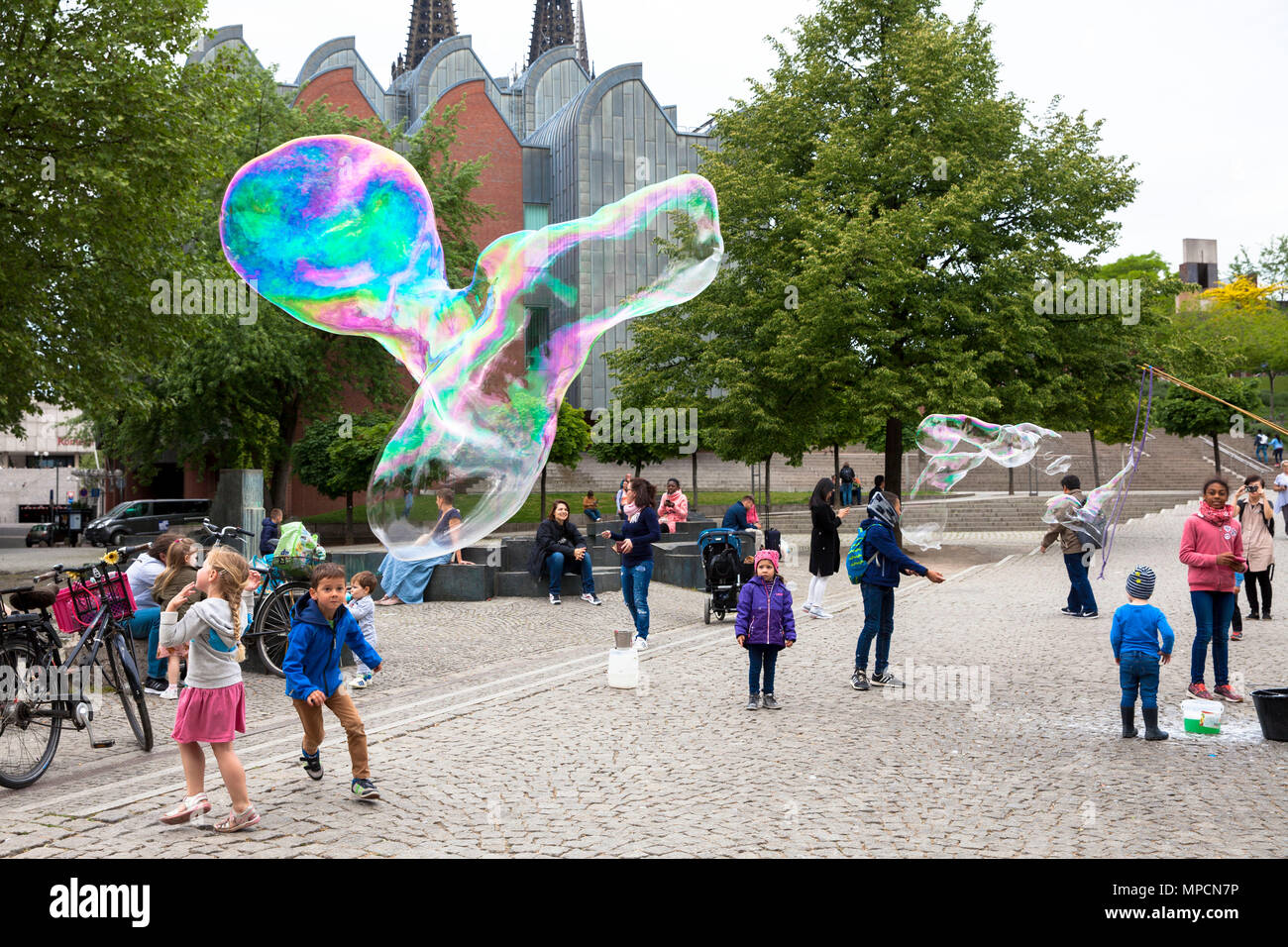 Europa, Deutschland, Köln, Mann macht riesige Seifenblasen am Rhein Garten im alten Teil der Stadt. Europa, Deutschland, Koeln, Mann macht grosse Stockfoto