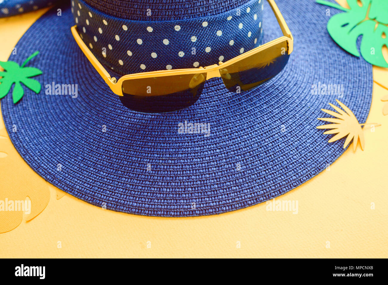 Beach Hut, Sonnenbrille und tropische Blätter auf einem gelben Hintergrund. Ferienhäuser Sommer flach Close-up mit kopieren. Stockfoto