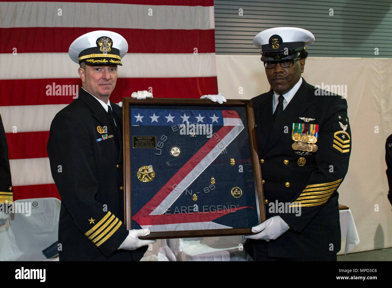 170203-N-AX 638-335 Newport News, Virginia (Feb. 3, 2017) Kapitän Todd A. Beltz, kommandierender Offizier USS Enterprise (CVN 65) und Command Master Chief Dwayne Huff pose mit der Inbetriebnahme Wimpel während der Enterprise Stilllegung Zeremonie. Enterprise wurde in Newport News Shipbuilding nach 55 Jahren der beauftragten Service stillgelegt. Enterprise eingesetzt 25 Mal während seiner operativen Karriere und ist der erste atomgetriebenen Flugzeugträger von der Marine stillgelegt. (U.S. Marine Foto von Mass Communication Specialist 2. Klasse Tyler Preston/Freigegeben) Stockfoto