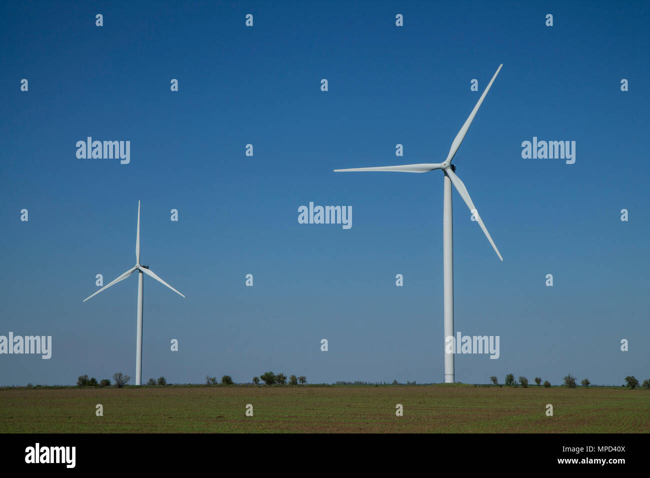 Windenergieanlagen auf Sonnenuntergang Himmel Hintergrund, Energie generator Natur freundlich. Frühling Feld. Stockfoto