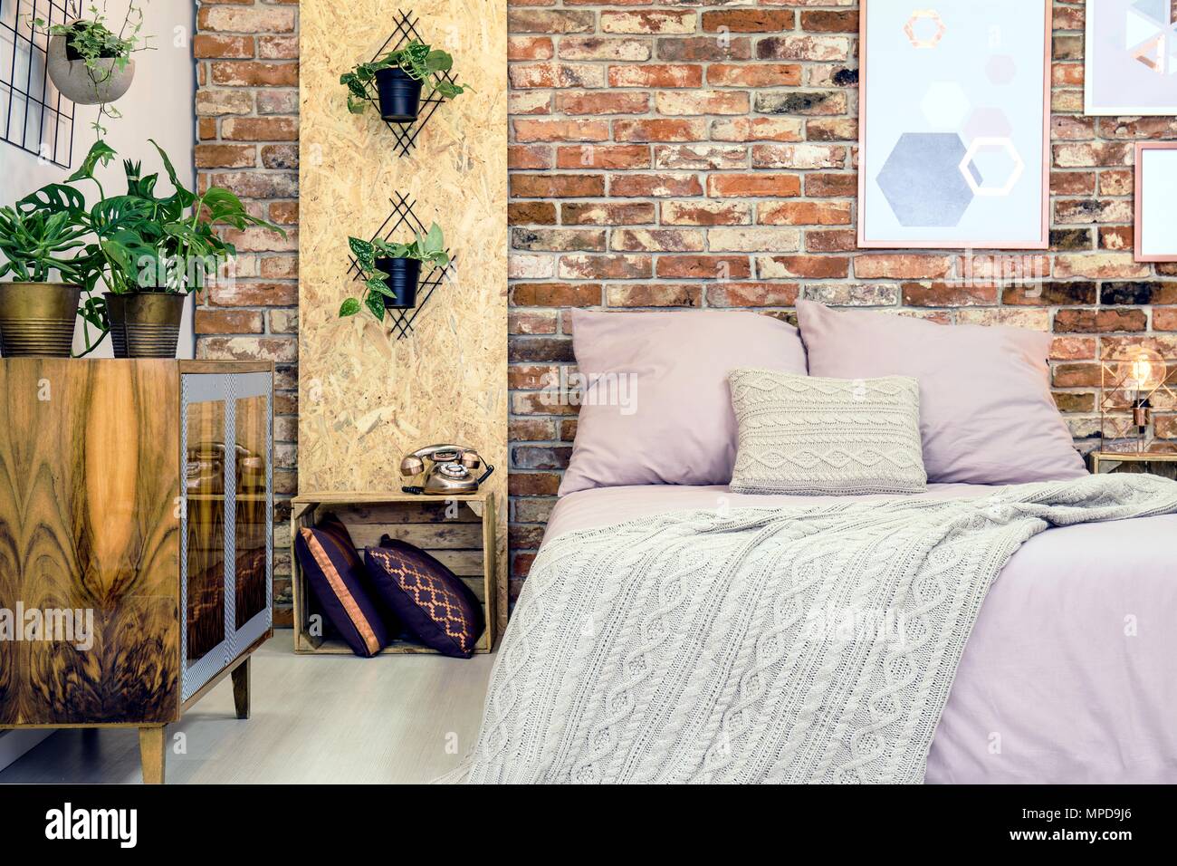 Industrielle Schlafzimmer mit Doppelbett und schmutzig rosa Bettwäsche Stockfoto