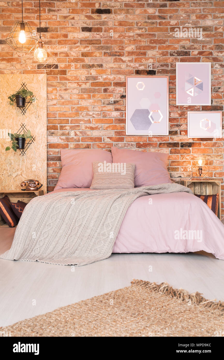 Modernes Schlafzimmer mit Doppelbett, rosa Bettwäsche und Wand Stockfoto