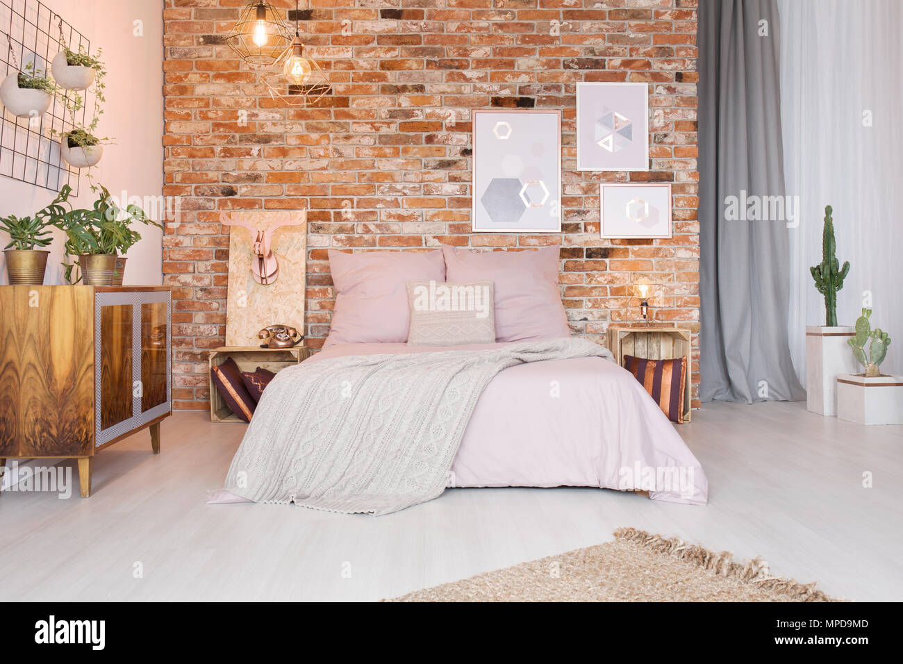 Gemütliches Schlafzimmer mit Doppelbett, Kommode und ethnischen Mauer Stockfoto
