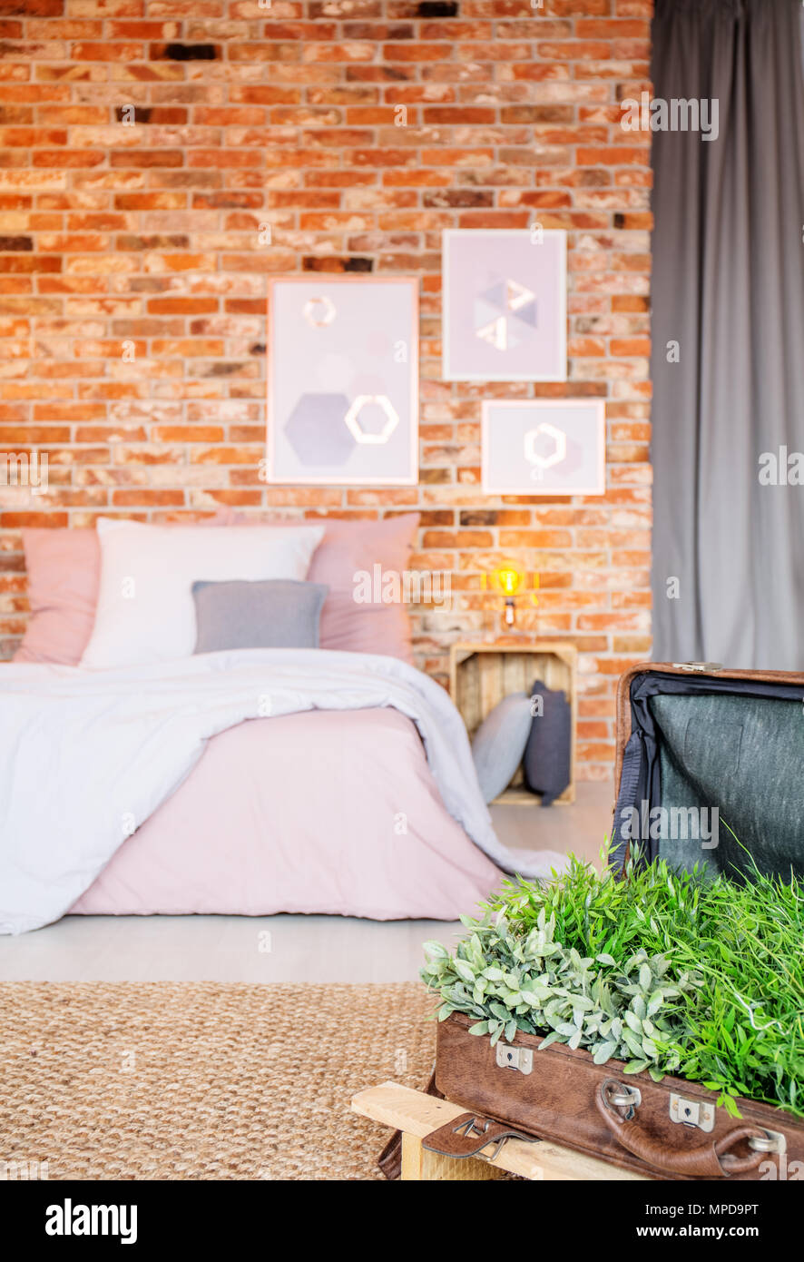 Industrielle Schlafzimmer mit Doppelbett und diy Koffer Flower Pot Stockfoto