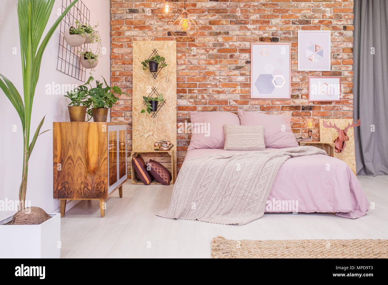 Schlafzimmer mit Doppelbett, Mauer und Grün dekorative Pflanzen Stockfoto