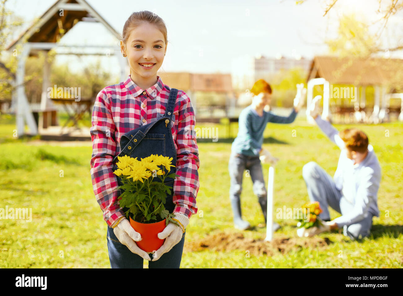 Freudige nettes Mädchen stehen im Garten Stockfoto