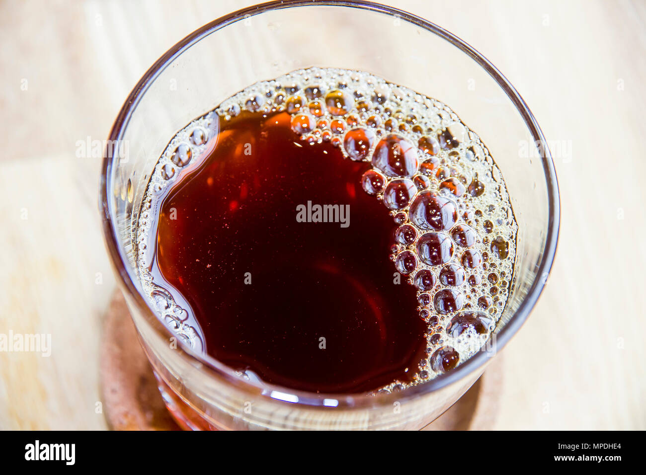 Frisch Kaffee mit Blasen und der Spiegelungen im Glas auf dem Tisch Top View gebraut Stockfoto