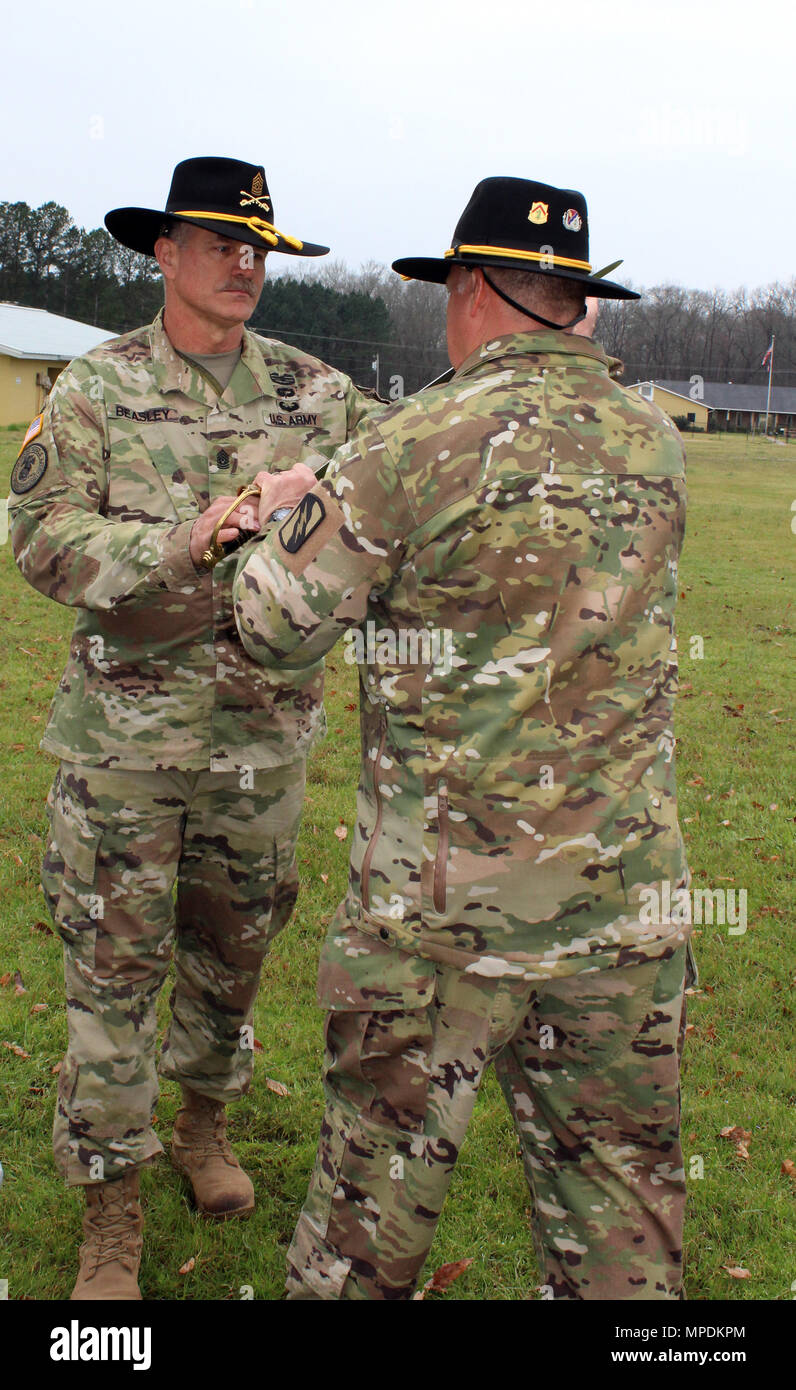 Eingehende Befehl Sgt. Maj. John Beasley übergibt die Unteroffiziere Schwert 1 Sgt. John Gist bei der Änderung von Verantwortung Zeremonie am 5. März 2017 im Camp McCain, Mississippi. Die Weitergabe des Schwertes Transfers formal die Befugnisse und Verantwortlichkeiten der Senior Advisor für die 1. Staffel, 98th Cavalry Regiment von Command Sgt. Maj. Gehirn Belue zu Command Sgt. Maj. John Beasley. (Mississippi National Guard Foto: Staff Sgt. Michael Needham, 102 d Public Affairs Abteilung) Stockfoto