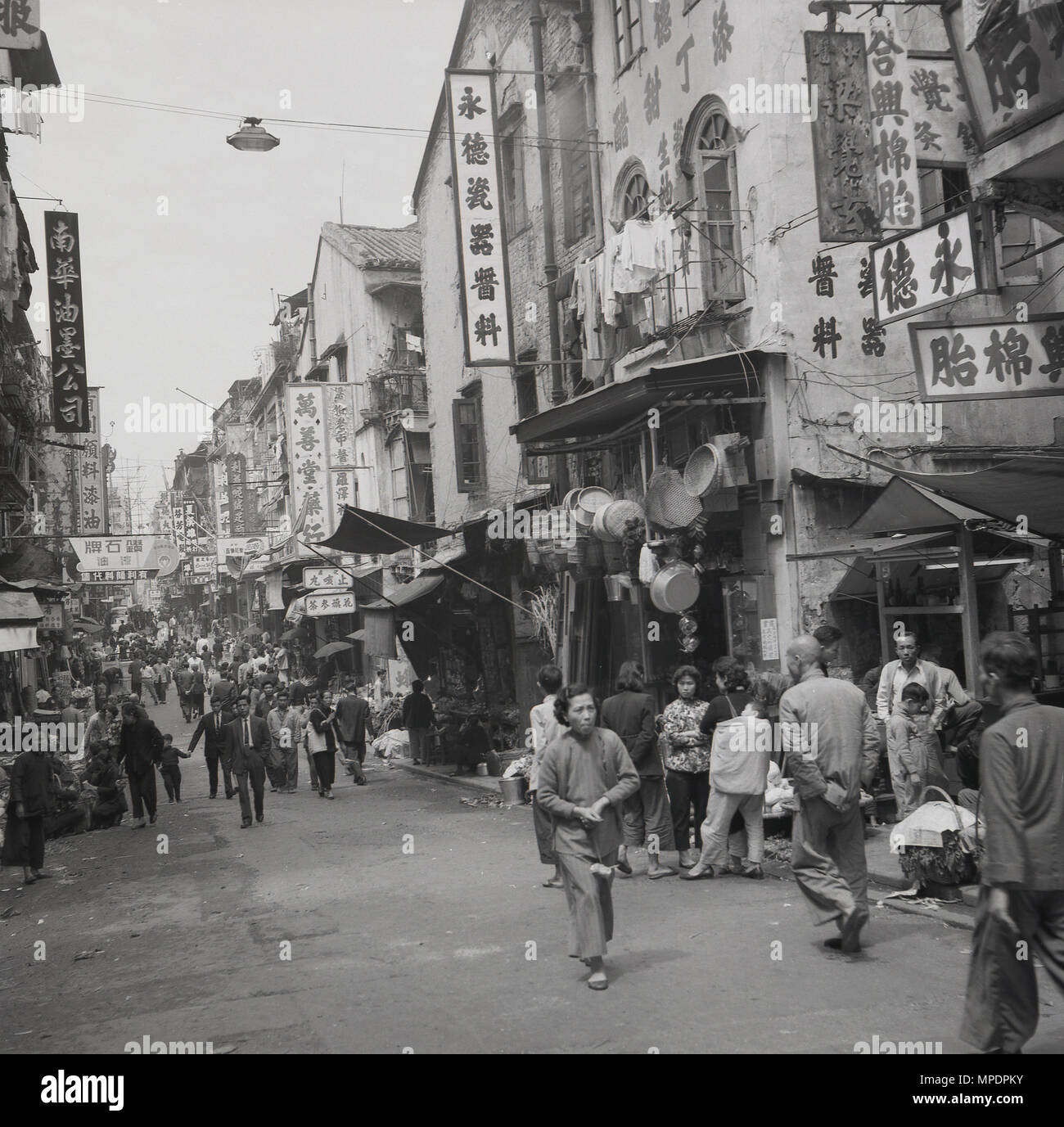 1950er Jahre, historische Bild von einem geschäftigen Stadtzentrum Straße in Hongkong. Nach dem Zweiten Weltkrieg, das Gebiet, immer noch eine britische Kolonie, sah das schnelle Wirtschaftswachstum, durch einen massiven Anstieg der Bevölkerung - von Mitte der 50er Jahre in Hong Kong Bevölkerungsdichte war eine der höchsten in der Welt gefördert wird, und eine Verlagerung von Unternehmen und Ressourcen, die aus dem kommunistischen China. Stockfoto 1950er Jahre, historische Bild von einem geschäftigen Stadtzentrum Straße in Hongkong. Nach dem Zweiten Weltkrieg, das Gebiet, immer noch eine britische Kolonie, sah das schnelle Wirtschaftswachstum, durch einen massiven Anstieg der Bevölkerung - von Mitte der 50er Jahre in Hong Kong Bevölkerungsdichte war eine der höchsten in der Welt gefördert wird, und eine Verlagerung von Unternehmen und Ressourcen, die aus dem kommunistischen China. Stockfoto