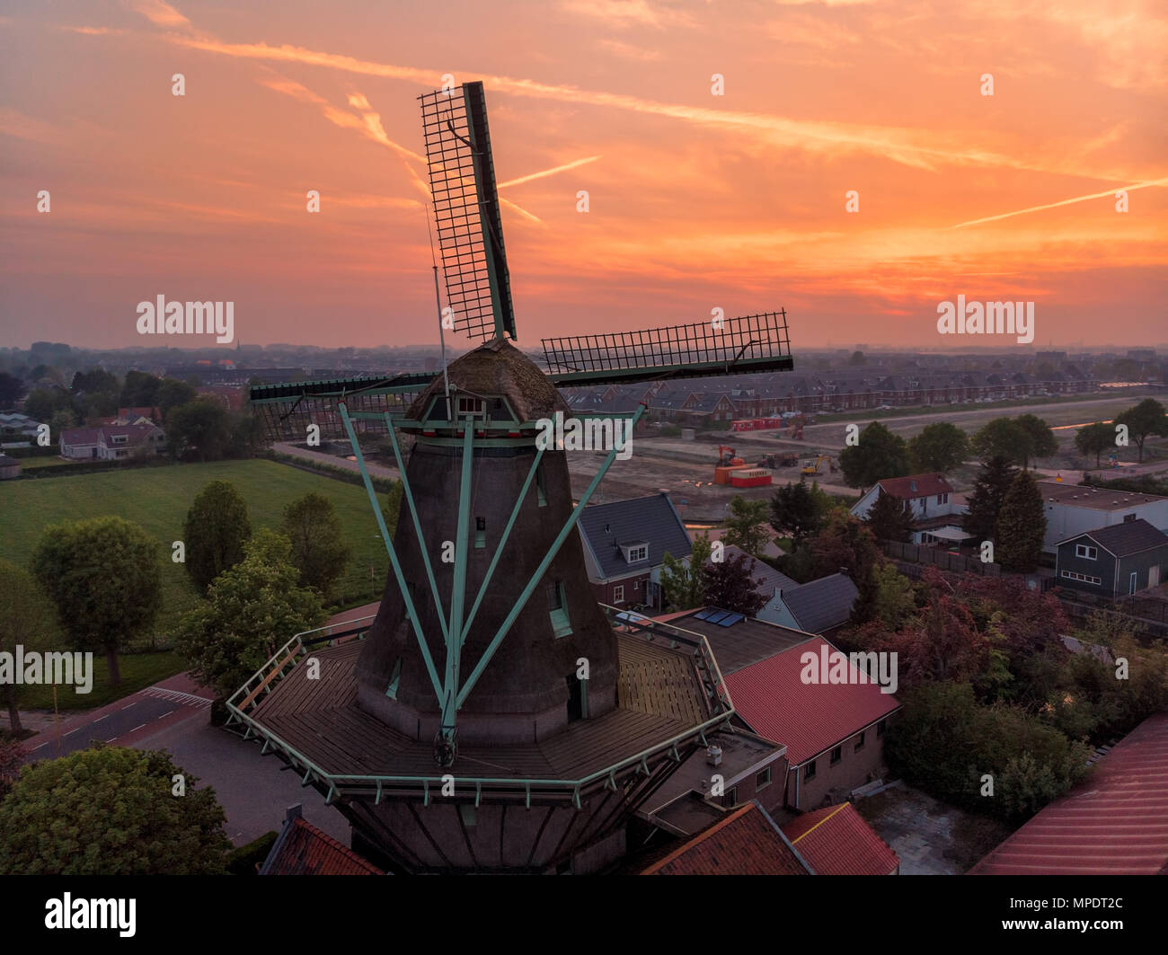 Sonnenuntergang mit einer alten Windmühle in den Niederlanden Stockfoto