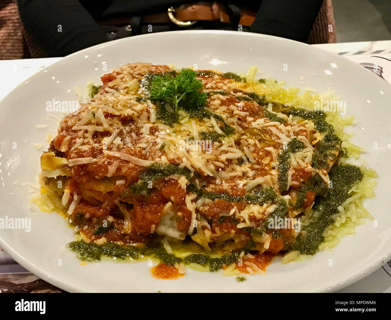 Traditionelle Hackfleisch Lasagne mit Bolognese und Pesto serviert im Restaurant. Ökologische Lebensmittel. Stockfoto