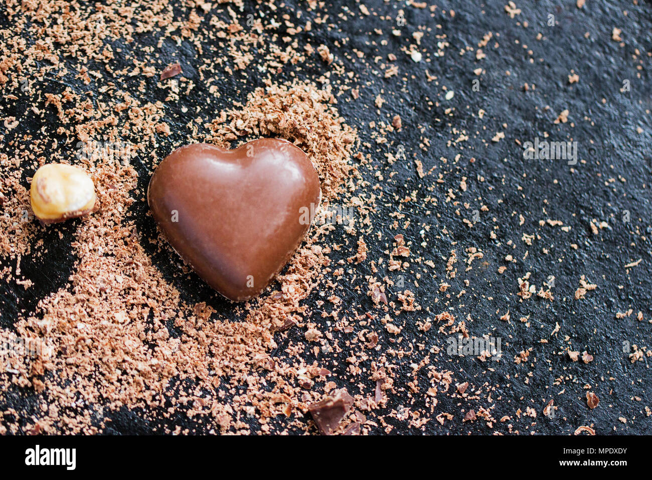 Herz Schokolade in Chocolate Chips auf schwarzem Hintergrund Stockfoto