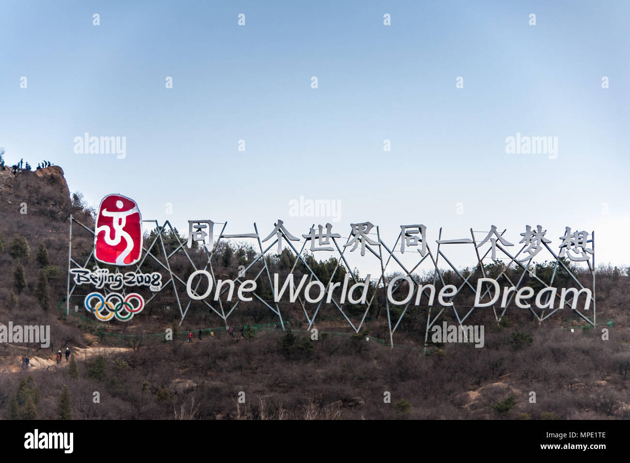 Peking, China - 28. April 2010: Chinesische Mauer bei Badaling. Riesiges Schild mit dem Logo der Olympischen Spiele 2008 und Motto One World One Dream. In grau-grün Stockfoto