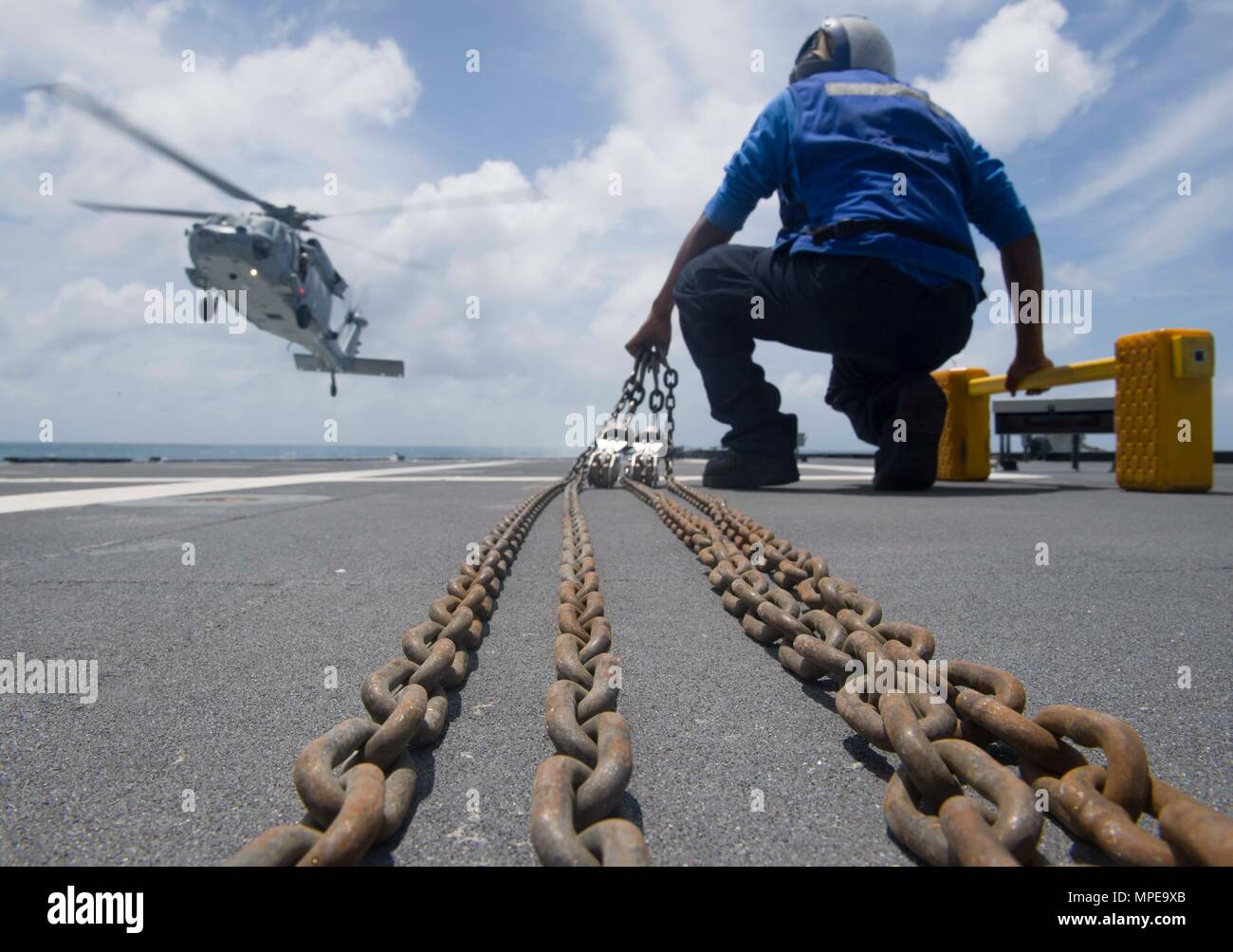 170213-N-WV 703-124 SOUTH CHINA SEA (Feb. 13, 2017) Fachkraft für Lagerlogistik Seaman Colin Pieters bereitet einen Unterlegkeil und Ketten auf einem MH-60S Seahawk Hubschrauber zu setzen, nachdem es landet auf dem Flugdeck der USS Coronado Littoral Combat Ship (LCS 4) Bei Flugbetrieb. Die derzeit auf einen Rotationsfehler Bereitstellung zu US-Siebten Flotte, Coronado ist ein schnelles und agiles Kriegsschiff maßgeschneidert auf Patrouille in der Region und die Arbeit littorals Hull - Hull mit Partner Seestreitkräfte, die siebte Flotte mit der flexiblen Möglichkeiten es heute und in Zukunft braucht. (U.S. Marine Foto von Mass Communication Specialist 2. Klasse Amy M. R Stockfoto