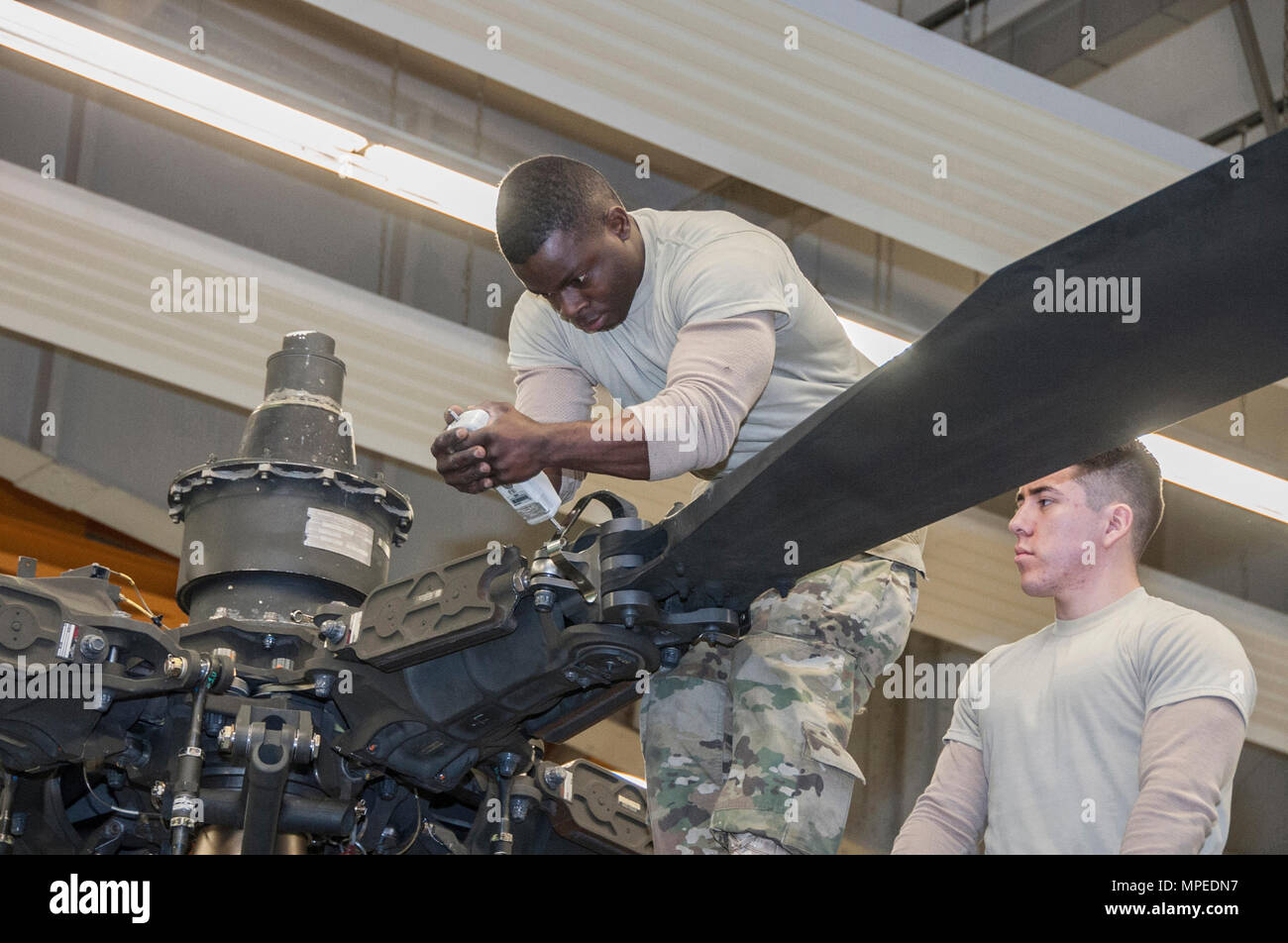 Spc. Ainsworth L. Carridice und SPC. Jose Castaneda mit Delta Unternehmen 1 Bataillon, 3 Aviation Regiment (Attack Reconnaissance) Verhalten phase Instandhaltung für ein AH-64 Apache Helikopter am Katterbach Army Airfield, Deutschland, 10.02.2017. Phase Wartungsinspektionen auftreten, die in regelmäßigen Abständen auf alle Flugzeuge, um sie betriebsbereit zu halten. (U.S. Armee Foto von visuellen Informationen Spezialist Georgios Moumoulidis, TSC Ansbach/Freigegeben). Stockfoto