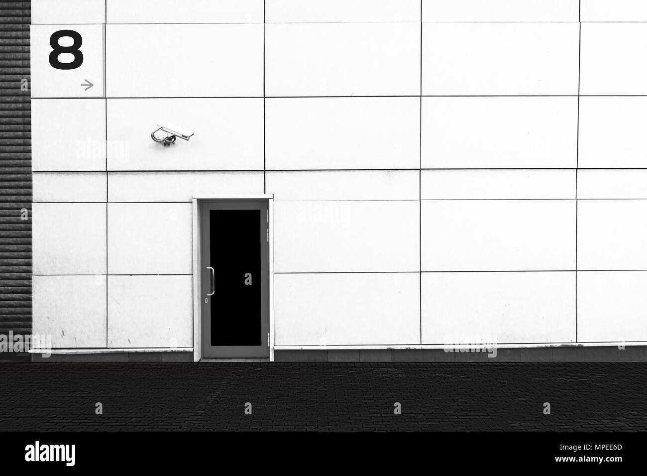 Die Mauer des Gebäudes, die Tür und der CCTV-Kamera. Sicherheit. Schwarzen und weißen Hintergrund. Stockfoto