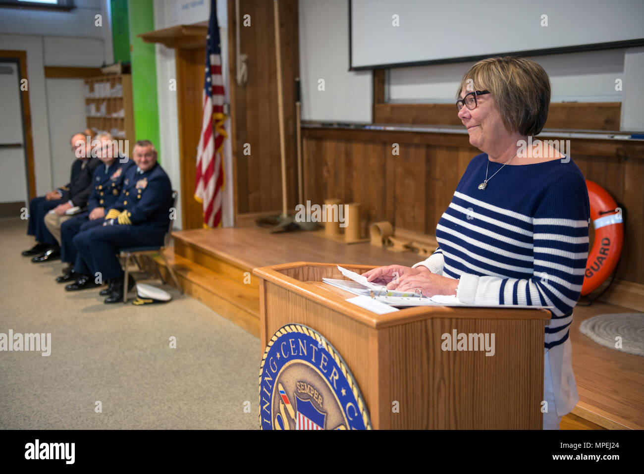 Patricia Webber-Hamilton, Tochter von Bernard C. Webber, spricht mit einer Masse an einer Feierstunde für die Bernard C. Webber Seemannschaft Training Service bei Coast Guard Training Center, Cape May, New Jersey, Freitag, Februar 17, 2017. Webber und Mitglieder ihrer Familie auf einer Veranstaltung, die der engagierte Training Center Seemannschaft Gebäude zu ihrem Vater für seinen heldenhaften Aktionen während der Rettung von 32 Besatzungsmitgliedern an Bord der Tanker Schiff Pendleton, Feb.18, 1952 aufgetreten. (U.S. Coast Guard Foto von Chief Warrant Officer John Edwards) Stockfoto