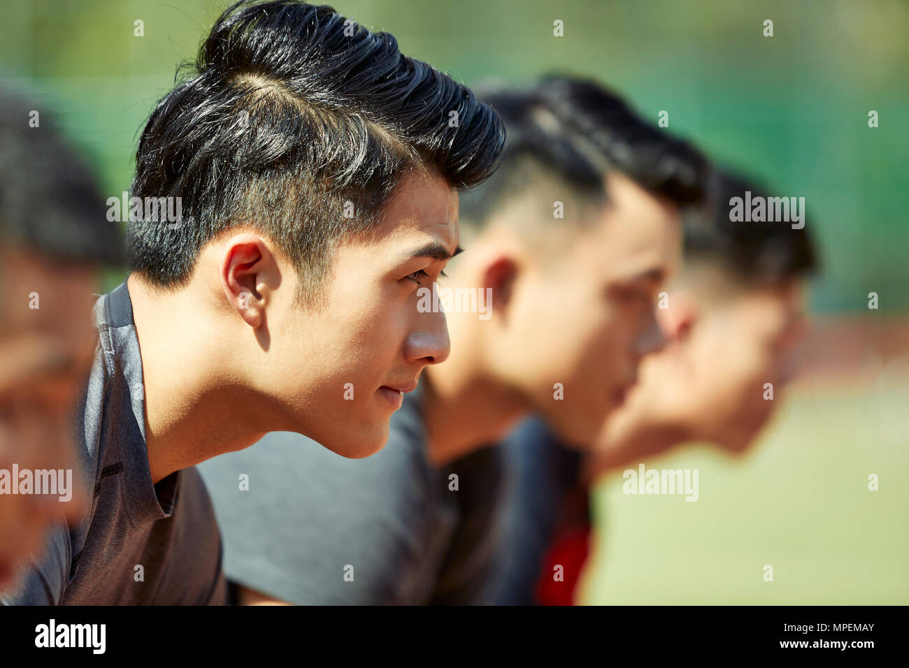 Nahaufnahmen der Gesichter von jungen asiatischen erwachsenen Läufer am Start. Stockfoto