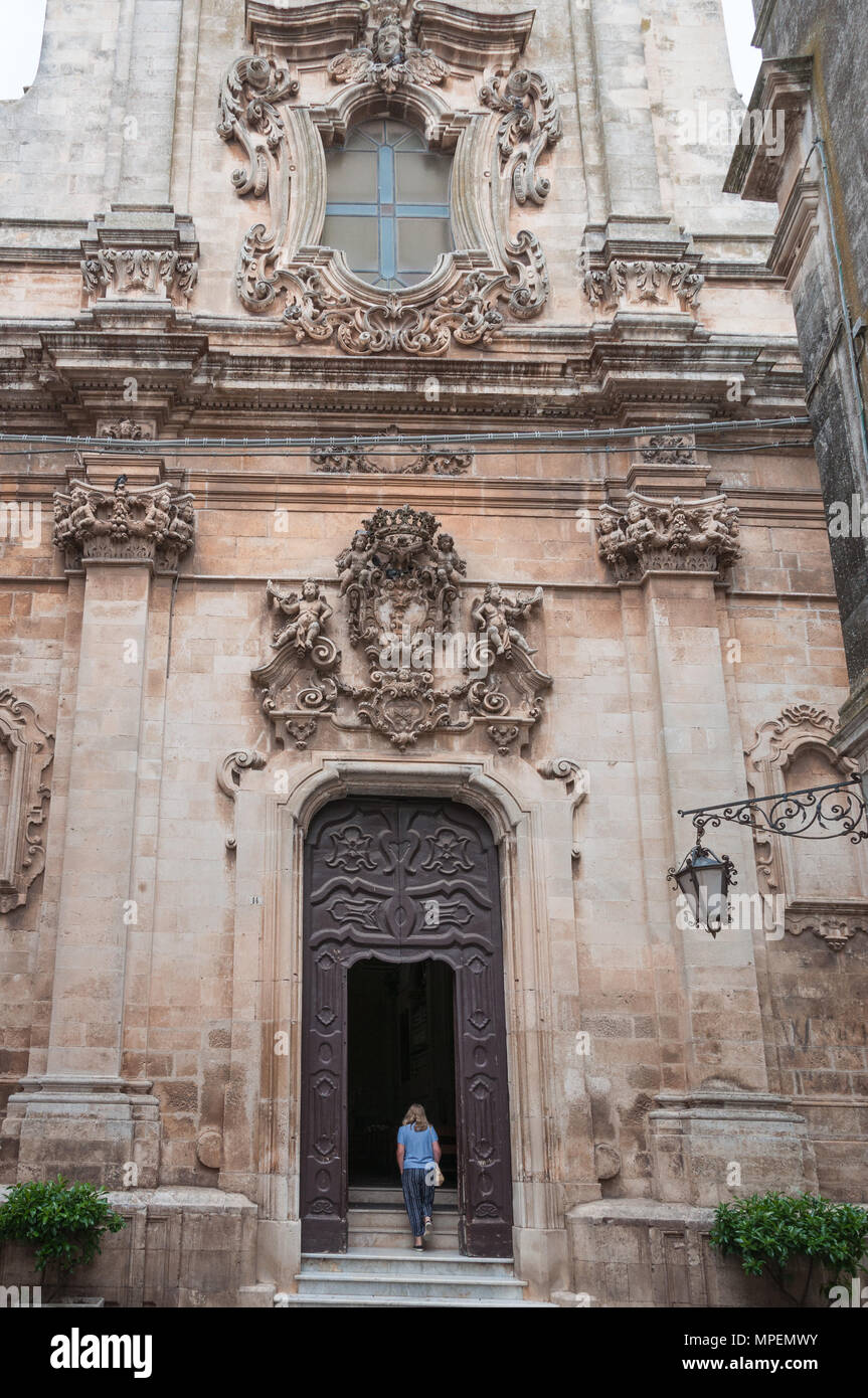 Eine einsame Frau erklimmt die Stufen zum Eingang von La Chiesa di San Domenico, Martina Franca, Apulien, Italien. Stockfoto