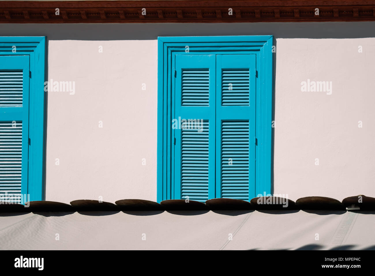 Blau, Geschlossene Fensterläden aus Holz auf beige Wand. Stockfoto