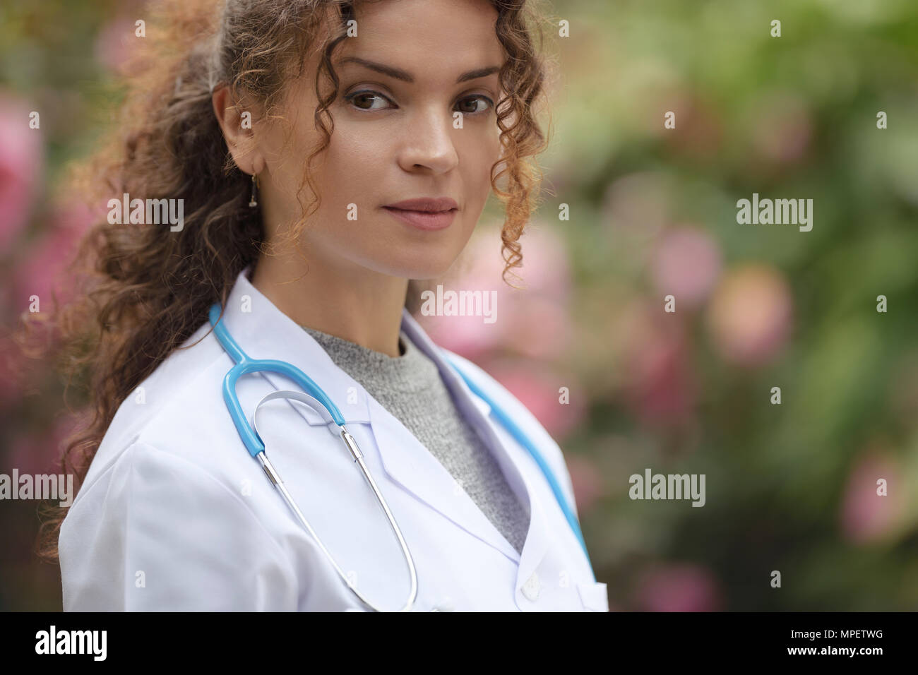 Porträt einer jungen Frau, Doktor, Arzt, praktischer Arzt in Laborkittel in natürlichen als auch für den Außenbereich geeignet. Stockfoto