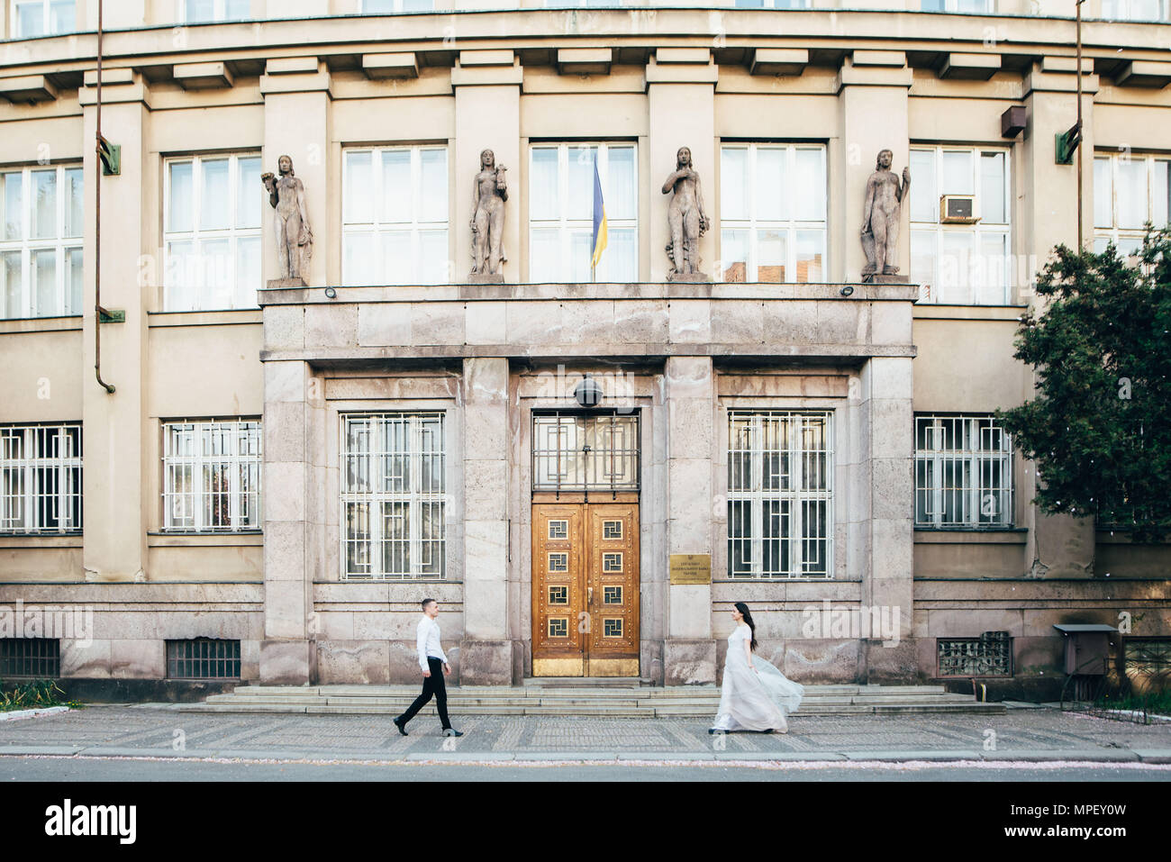 Ein junger Schimpanse Paare um die Stadt zu Fuß zu erkunden auf dem Hintergrund eines großen Gebäudes. Liebe Stockfoto