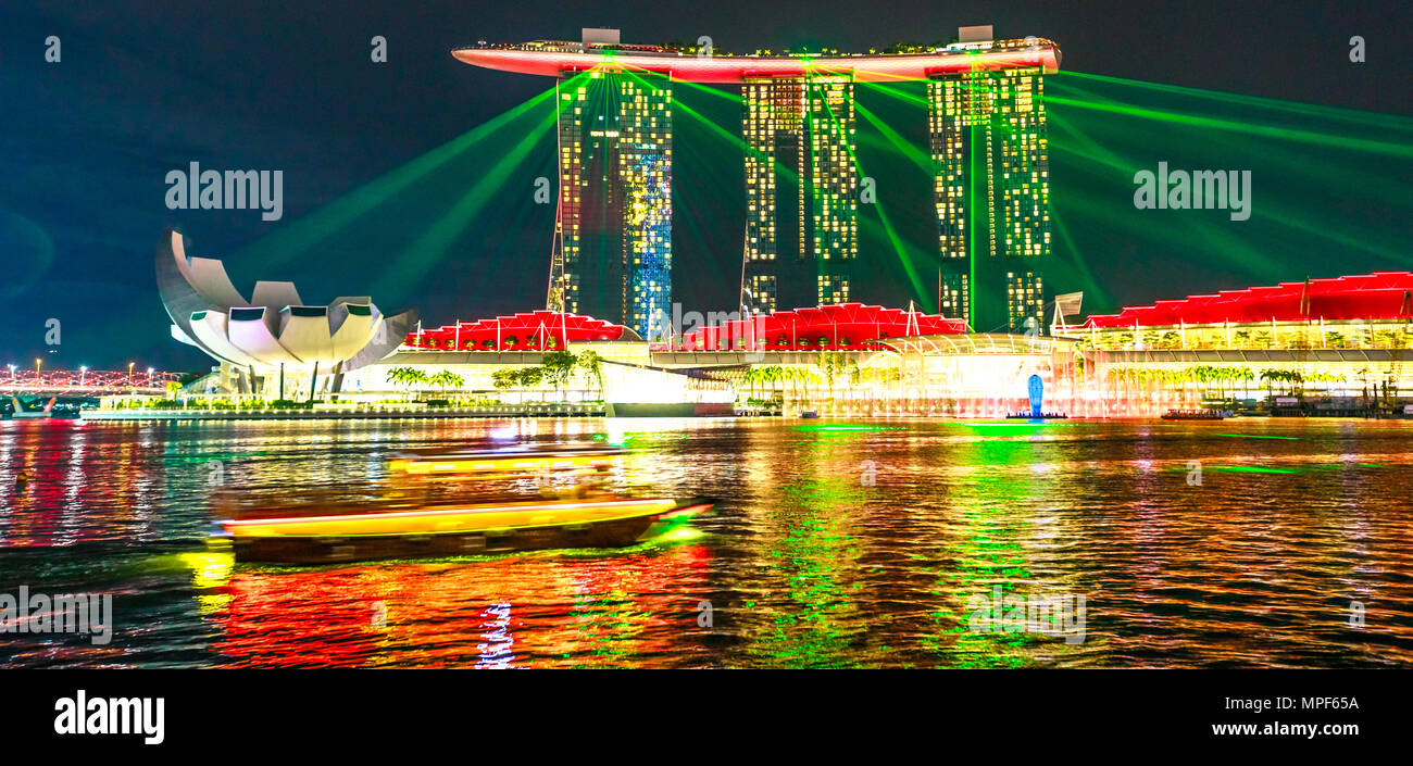 Singapur - April 27, 2018: Bunte laser Show am Abend an der Marina Bay Sands Hotel Casino und ArtScience Museum mit dem Boot auf den Gewässern der Marina Bay Waterfront Promenade in der Marina Bay in Singapur. Stockfoto