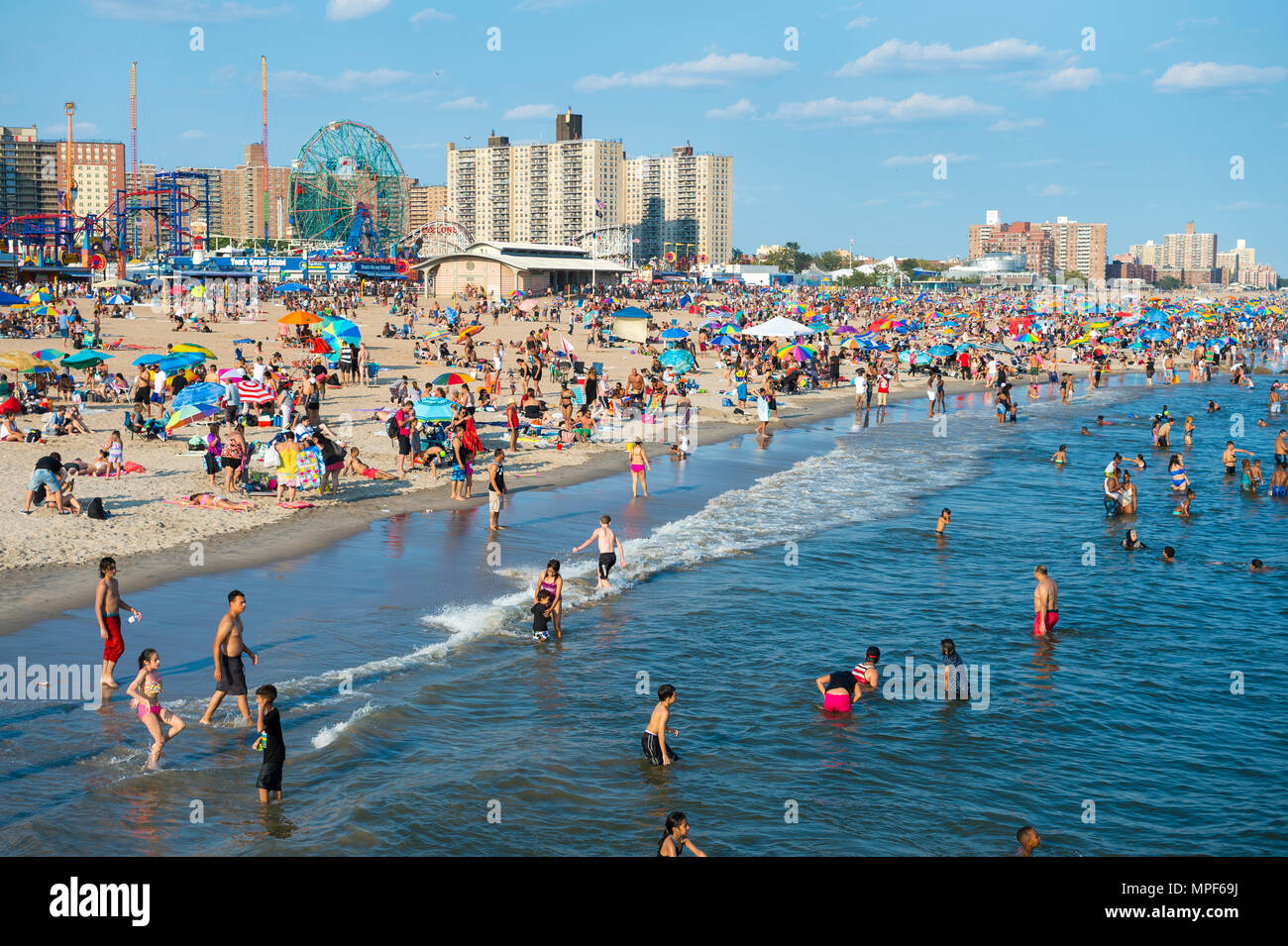 NEW YORK CITY - 20. AUGUST 2017: Blick auf Menschen mit einem Sommertag auf überfüllten Coney Island Strand und die Promenade. Stockfoto
