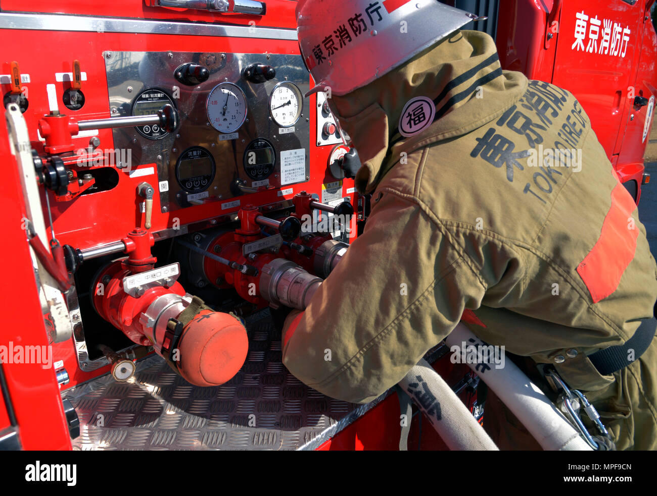 Ein Feuerwehrmann der Fussa Feuerwehr inspiziert Schläuche und Ausrüstung auf dem Luftwaffenstützpunkt Yokota, Japan, bevor er ein Feuerwehrtraining für Fahrzeuge durchführt. Die Übung, an der die 374th Civil Engineer Squadron beteiligt ist, ermöglicht es den Abteilungen, Techniken, Koordination und Notfalleinsatzfähigkeiten zu demonstrieren. Die gemeinsame Schulung verbessert die Kenntnisse, Teamarbeit, Zusammenarbeit zwischen Behörden und die Bereitschaft für Feuerlöschungs- und Fahrzeugnotfälle in der Praxis. Stockfoto