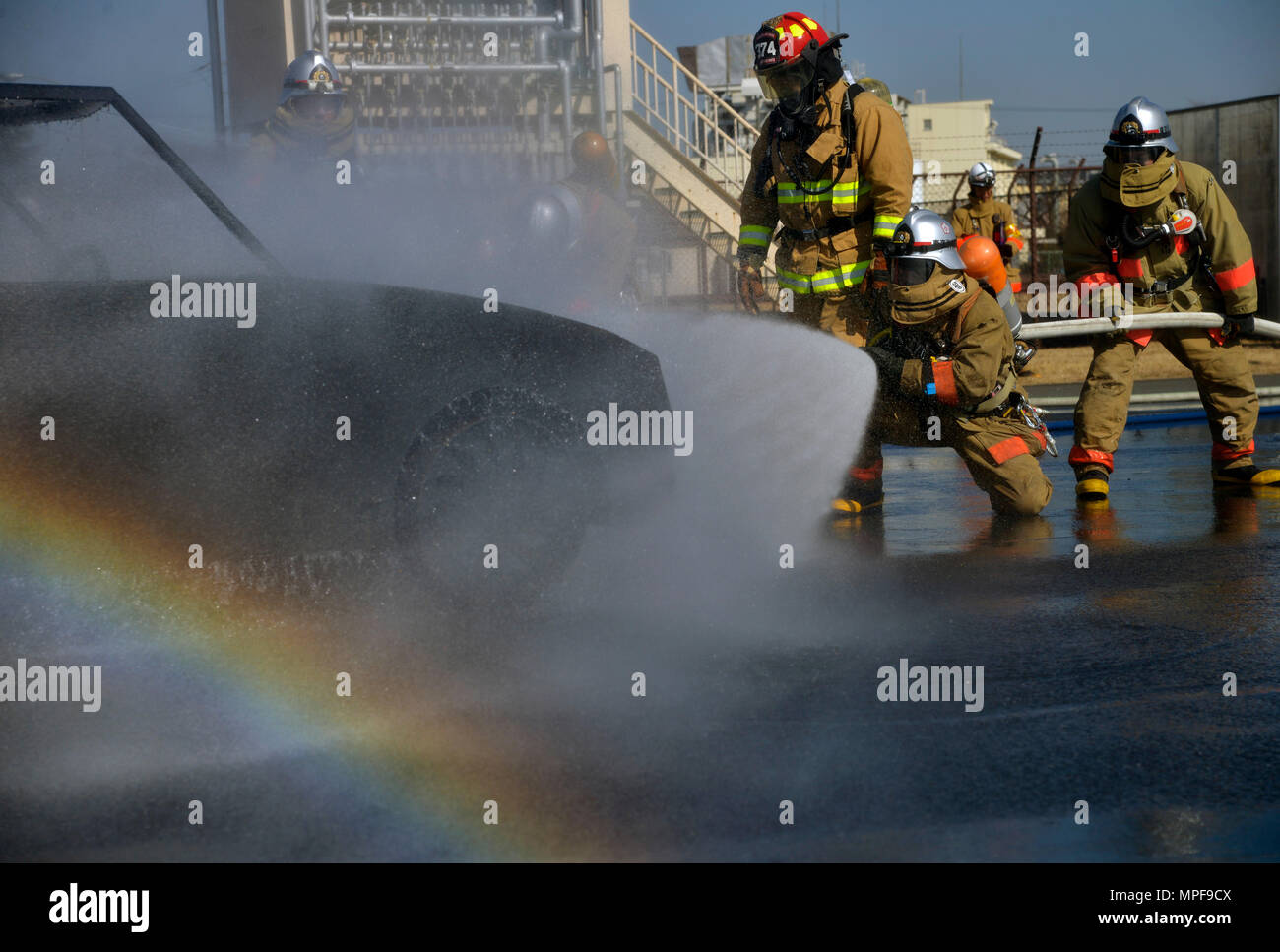 Der Crewchef der 374th Civil Engineer Squadron überwacht das Personal der Fussa Fire Department bei einem Fahrzeugfeuerschulungsszenario auf der Yokota Air Base, Japan. Die Übung konzentriert sich auf Sicherheit, geeignete Techniken zur Brandbekämpfung, Teamarbeit, Zusammenarbeit zwischen Behörden und Einsatzbereitschaft. Die Vorgesetzten stellen sicher, dass die Verfahren befolgt werden, das Personal effektiv geschult wird und die Notfalleinsatzkapazitäten bei realen Vorfällen gestärkt werden. Stockfoto