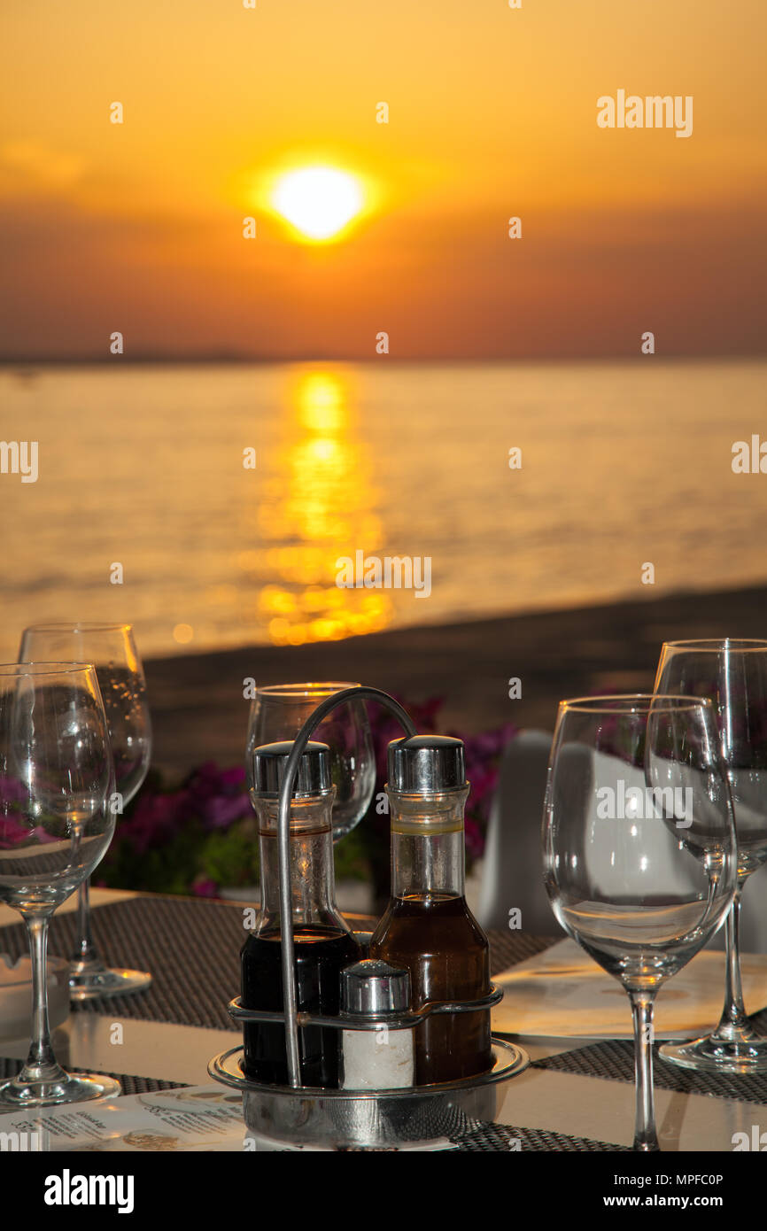 Herrliche goldene Rot und Orange lebendige pulsierende Sonnenuntergang über dem Meer im Hafen von Zadar an der Adriatischen Küste Kroatien von einem Tisch im Restaurant gesehen Stockfoto