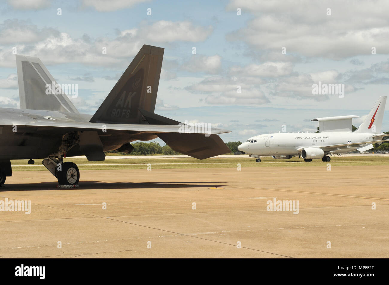 Die Royal Australian Air Force E-7A Wedgetail Taxis vorbei an einer US Air Force 90th Fighter Squadron F-22 Raptor bei RAAF Base Tindal, Australien, 24.02.2017. Zwölf F-22 Raptors und ca. 200 US Air Force Piloten sind in Australien als Teil der erweiterten Luft Zusammenarbeit, einer Initiative unter der Kraft Haltung Abkommen zwischen den USA und Australien. (U.S. Air Force Foto: Staff Sgt. Alexander Martinez) Stockfoto