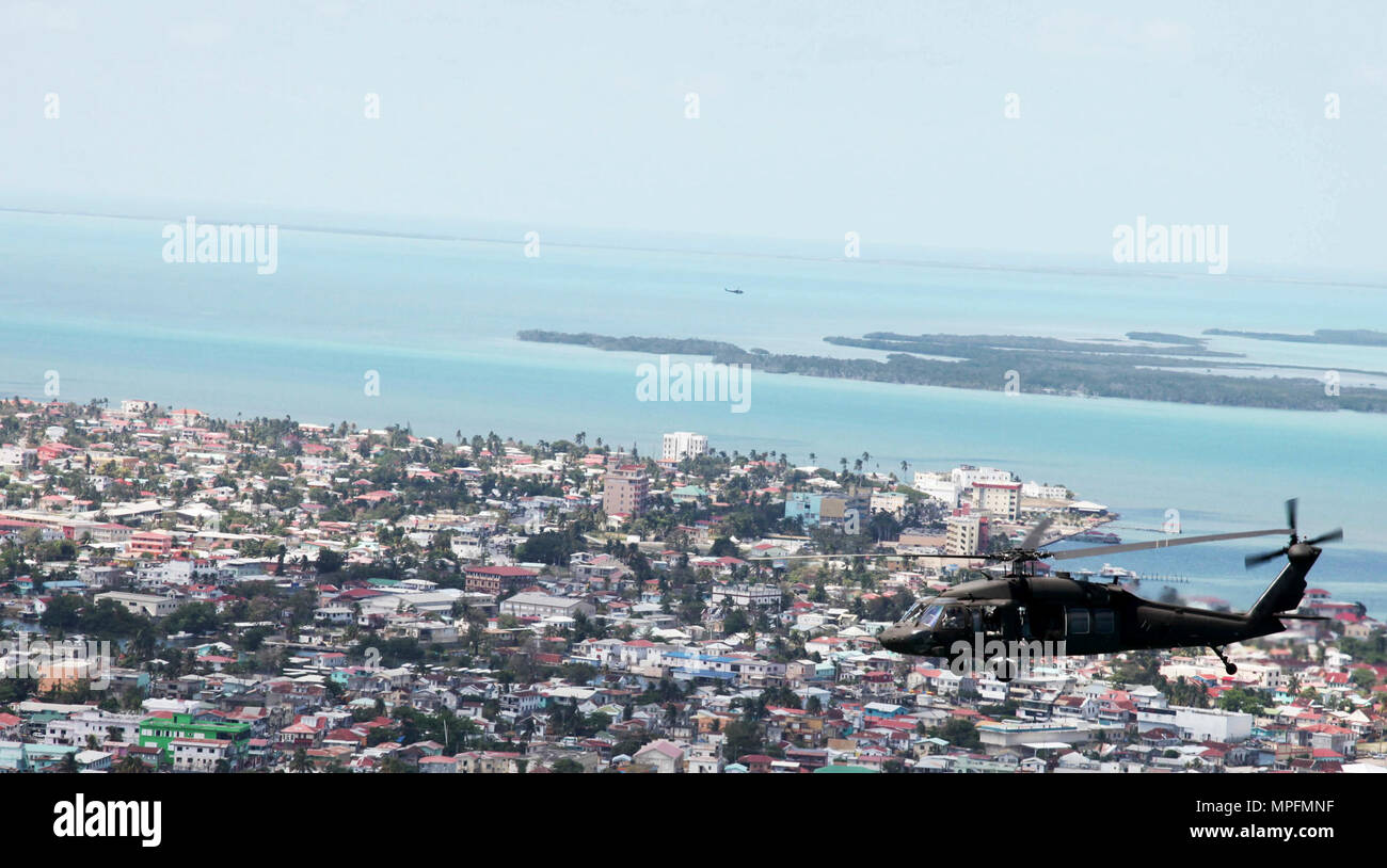 Ein UH-60 Blackhawk Hubschrauber von einer Firma, 1/150th Assault Helicopter Bataillon, fliegt über Belize City während Transport von Soldaten und Marines auf dem Weg zurück von Dangriga, Belize, 10. April 2017. Die 1/150th ist die Bereitstellung von Lift und medevac, soweit erforderlich, über den Horizont 2017, ein US Southern Command - geförderte, Armee südlich-led-Übung für humanitäre und technische Dienstleistungen für die Gemeinschaften in der Notwendigkeit, die Unterstützung der USA für Belize zur Verfügung zu stellen. Stockfoto