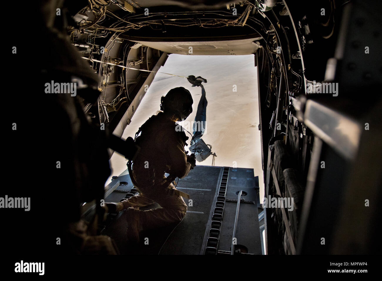 Ein US-Marine, mit Marine Medium Tiltrotar Squadron - 165 (VMM-165), einen Fallschirm Bündel auf der Rückseite eine MV-22 Osprey bei einer gemeinsamen airdrop Mission in Südwestasien, auf März 9, 2017. (U.S. Armee Foto: Staff Sgt. Dalton Smith) Stockfoto