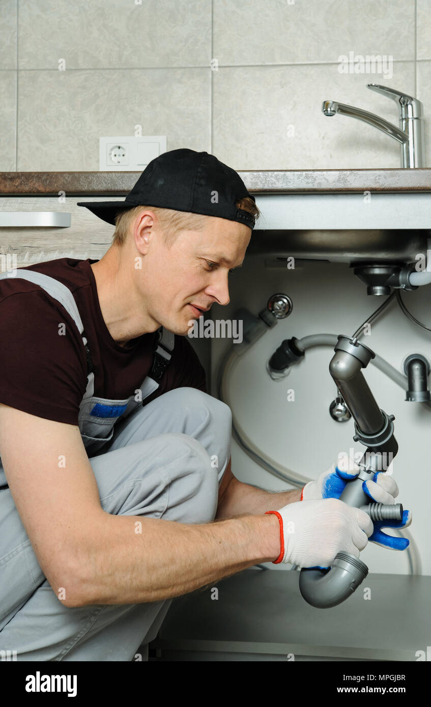 Arbeitnehmer setzt Falle für die Küchenspüle. Stockfoto