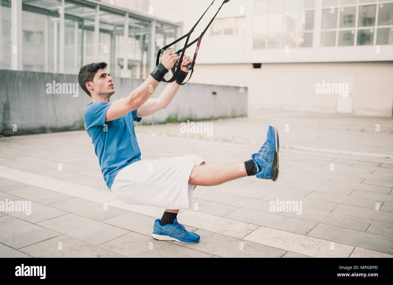 Sportlich männlich Trainieren mit Fitness trx Träger auf der Straße Stockfoto